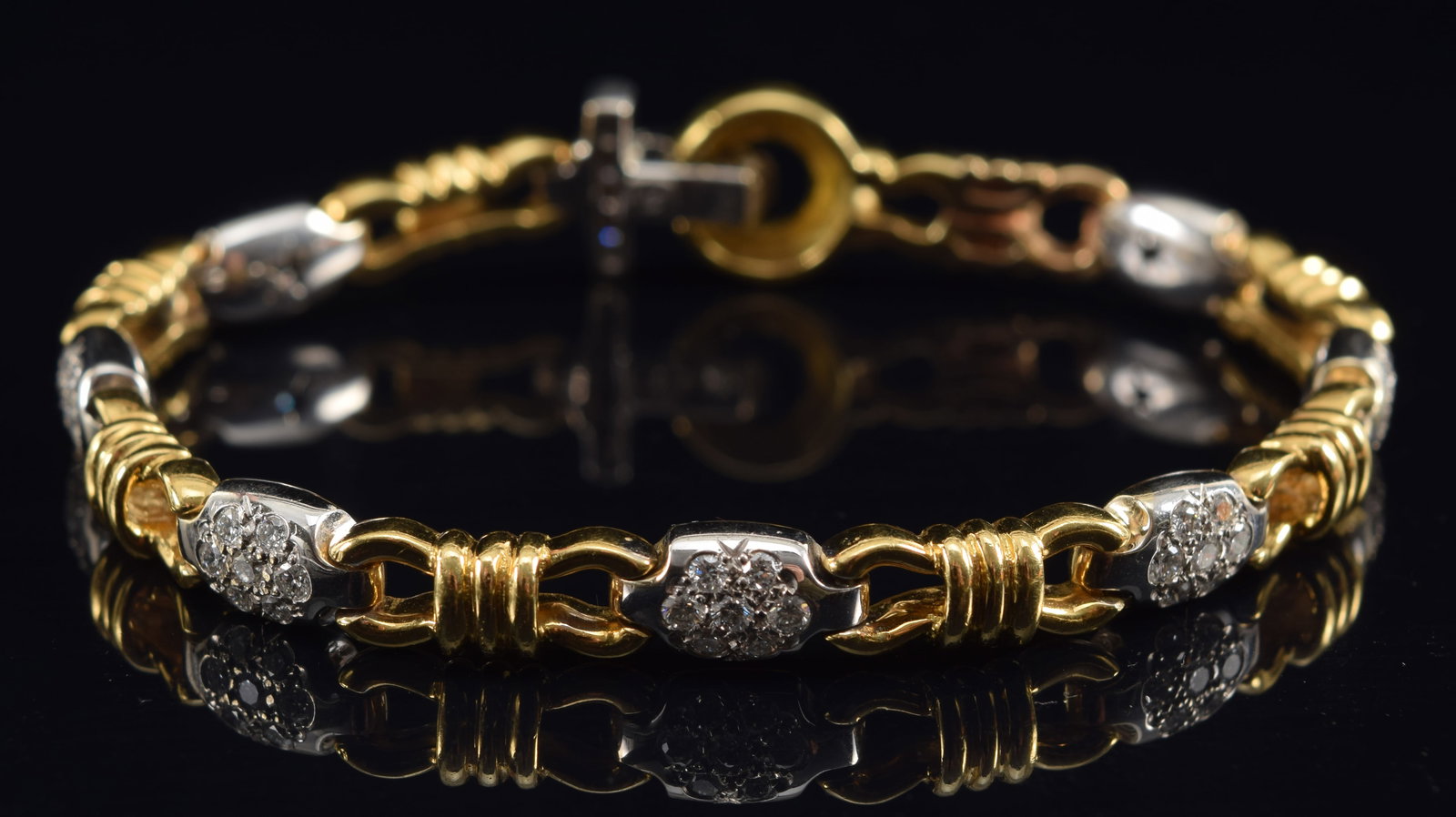 18K white and yellow gold diamond mounted bracelet. Alternating links of diamond pave white gold and: 18K white and yellow gold diamond mounted bracelet. Alternating links of diamond pave white gold and yellow gold hooks. Each white gold section set with 7 round cut diamonds, about 2.2mm diameter each