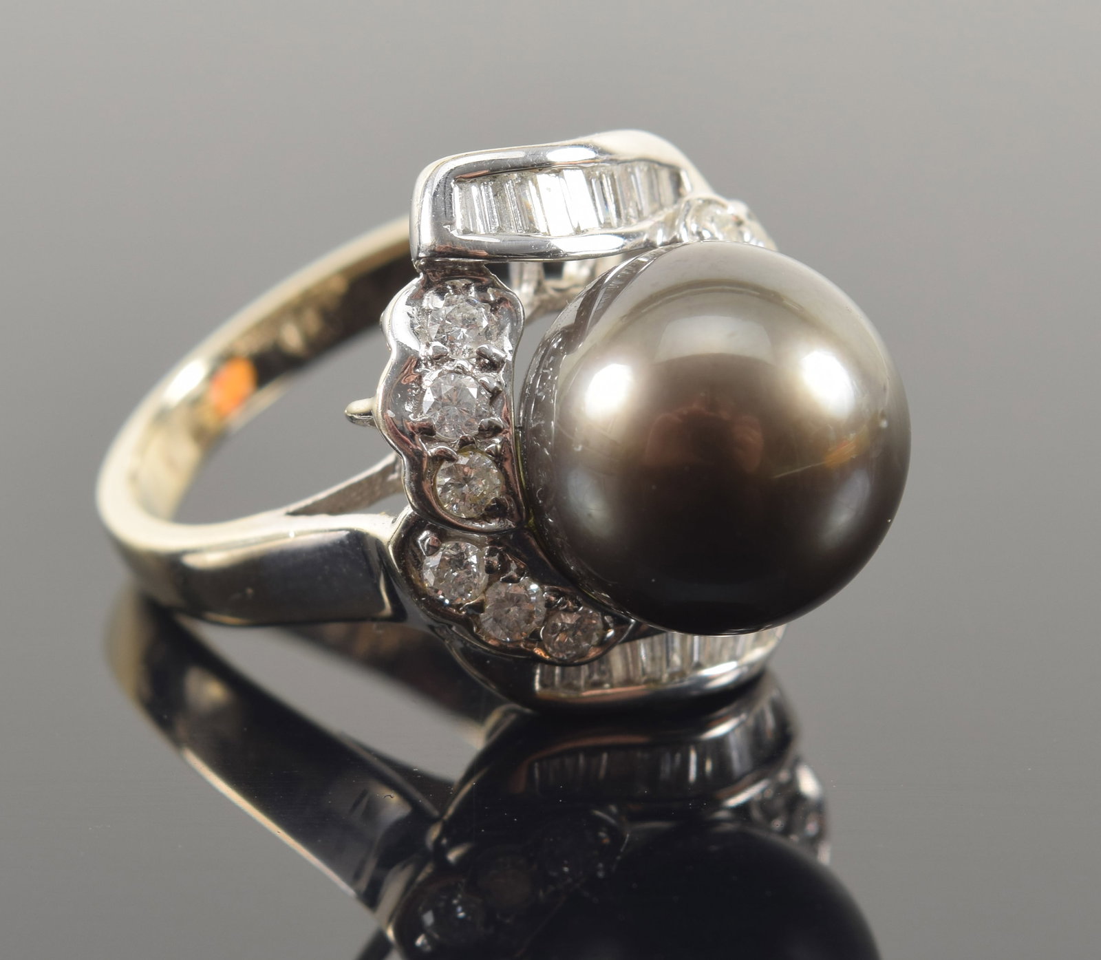 14K white gold black cultured pearl and diamond mounted ring. Large pearl measuring approx. 11.4mm: 14K white gold black cultured pearl and diamond mounted ring. Large pearl measuring approx. 11.4mm diameter. Surrounded by round and baguette cut diamonds. Marked 14K 585 and IPS. Ring size 6.25. 7.2 