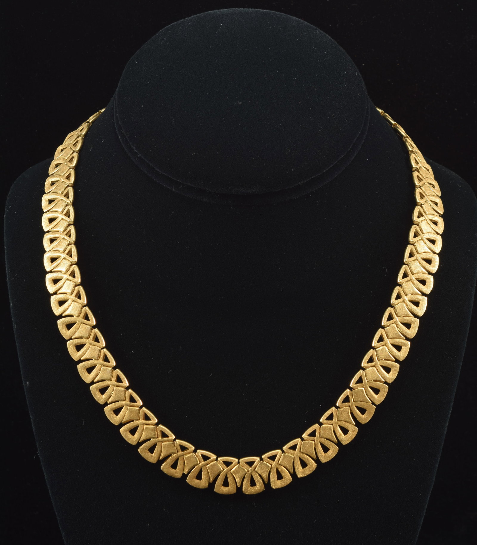 18K gold mid century modern design necklace with reticulated vertical bow tie pattern. Double sided: 18K gold mid century modern design necklace with reticulated vertical bow tie pattern. Double sided textured and polished finishes. Clasp marked 18K and 750. 17.25in length. 44.2 grams.