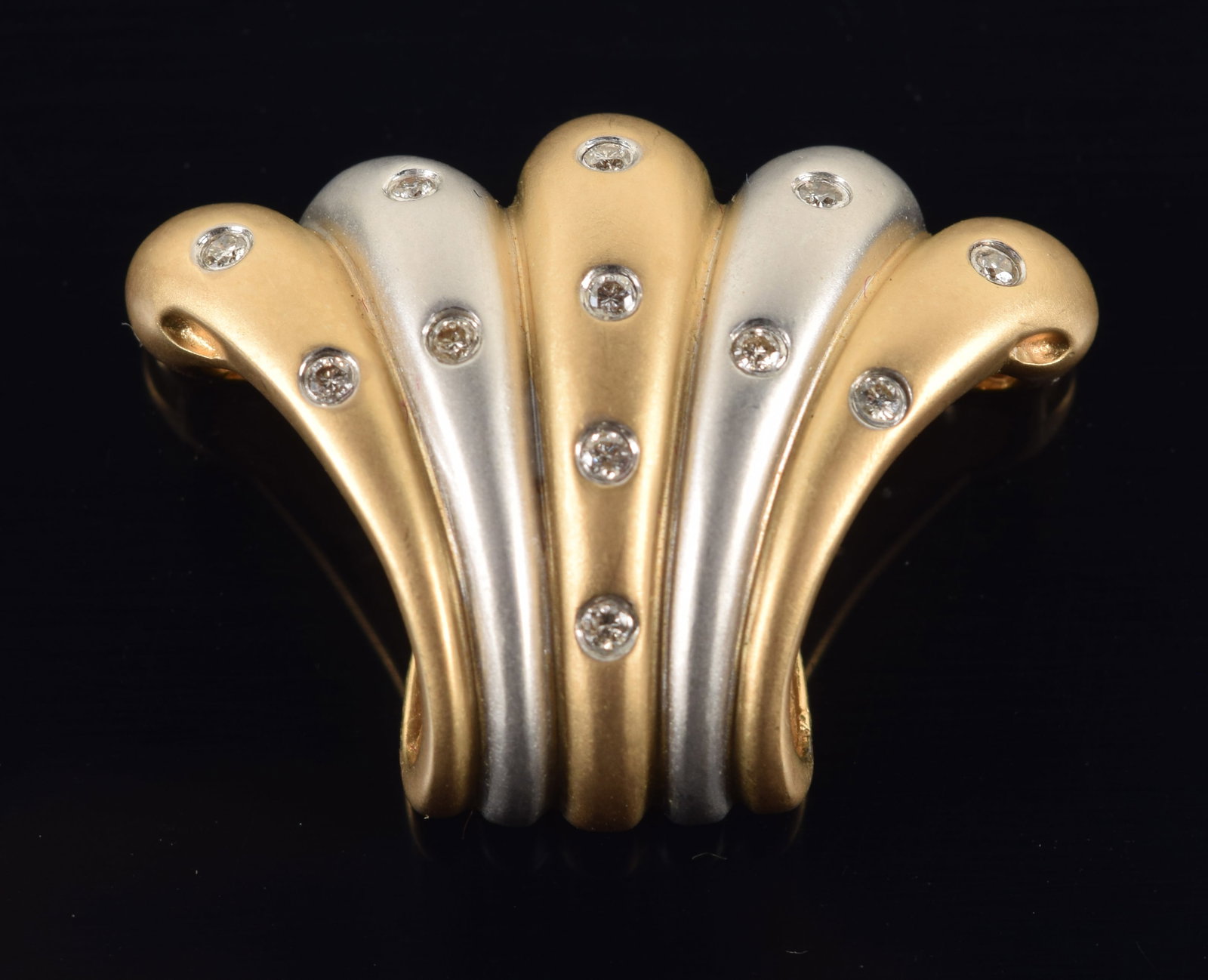 14K white and yellow gold diamond mounted fan shaped slide pendant. Satin finish. 12 small round cut: 14K white and yellow gold diamond mounted fan shaped slide pendant. Satin finish. 12 small round cut diamonds, each about 1.5mm diameter. Marked 14K, 585, and WLC on reverse. 1.25in wide. 7.1 grams.