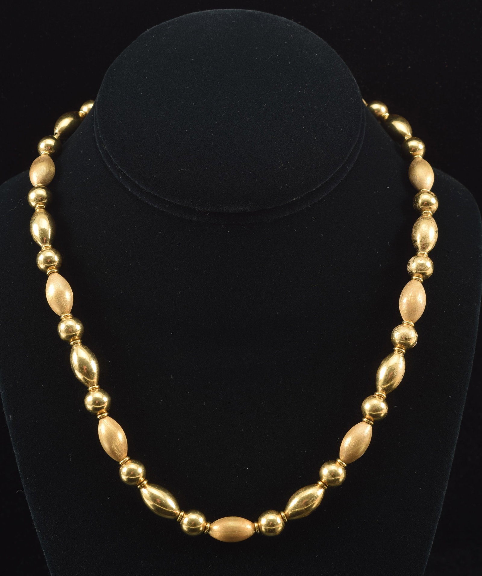 18K gold satin and polished bead necklace. Alternating pattern of spherical and tapered cylindrical: 18K gold satin and polished bead necklace. Alternating pattern of spherical and tapered cylindrical beads. Clasp marked 18K and serial mark. Necklace length: 17.5in. 46.3 grams.