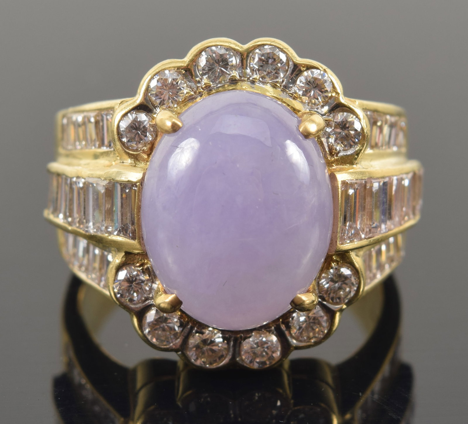 18K gold 8.17CT lavender jadeite and diamond mounted ring. Oval jade cabochon measuring 14.1 x 11.1: 18K gold 8.17CT lavender jadeite and diamond mounted ring. Oval jade cabochon measuring 14.1 x 11.1 x 6.2mm and weighing approx. 8.15ct. Semi translucent violet-purple color. Surrounded by two semi-ci