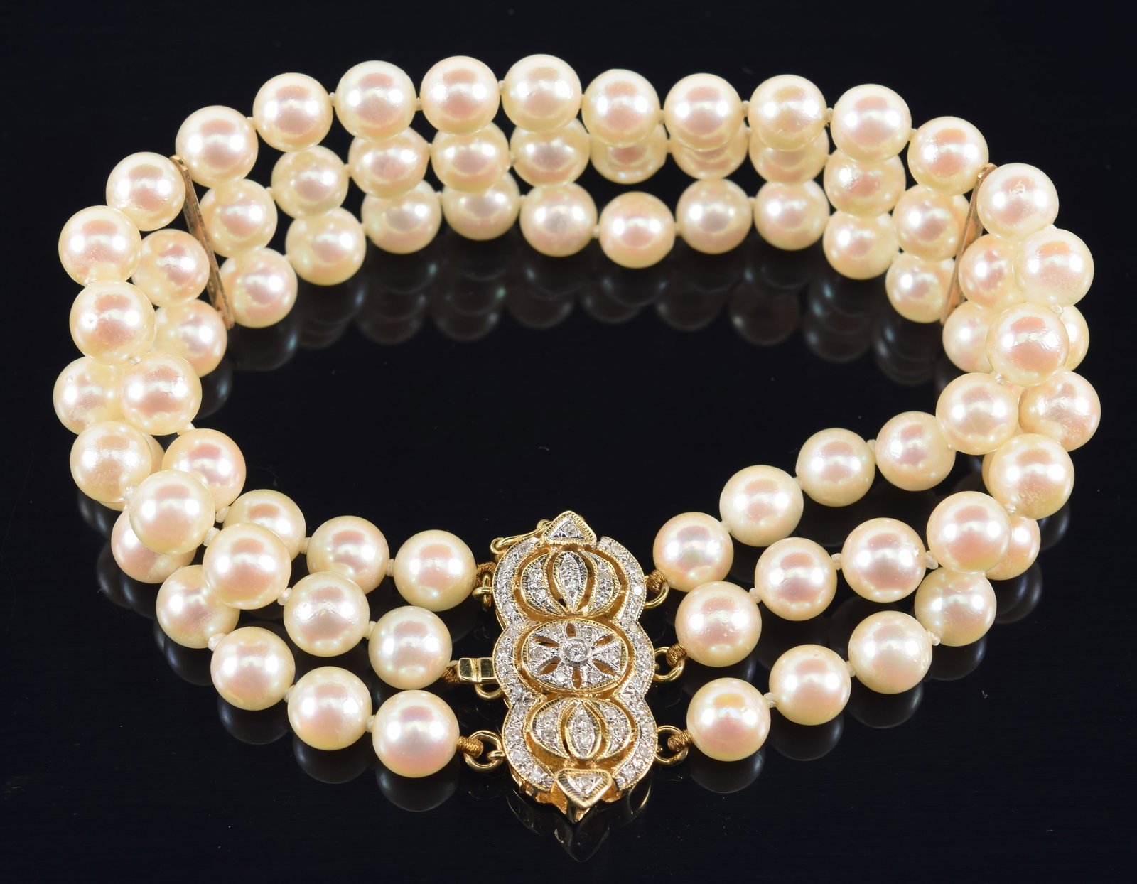 14K gold ornate diamond mounted clasp 3-strand pearl bracelet. Reticulated clasp set with numerous: 14K gold ornate diamond mounted clasp 3-strand pearl bracelet. Reticulated clasp set with numerous small round cut diamonds. Marked 14K. 7.5in length.