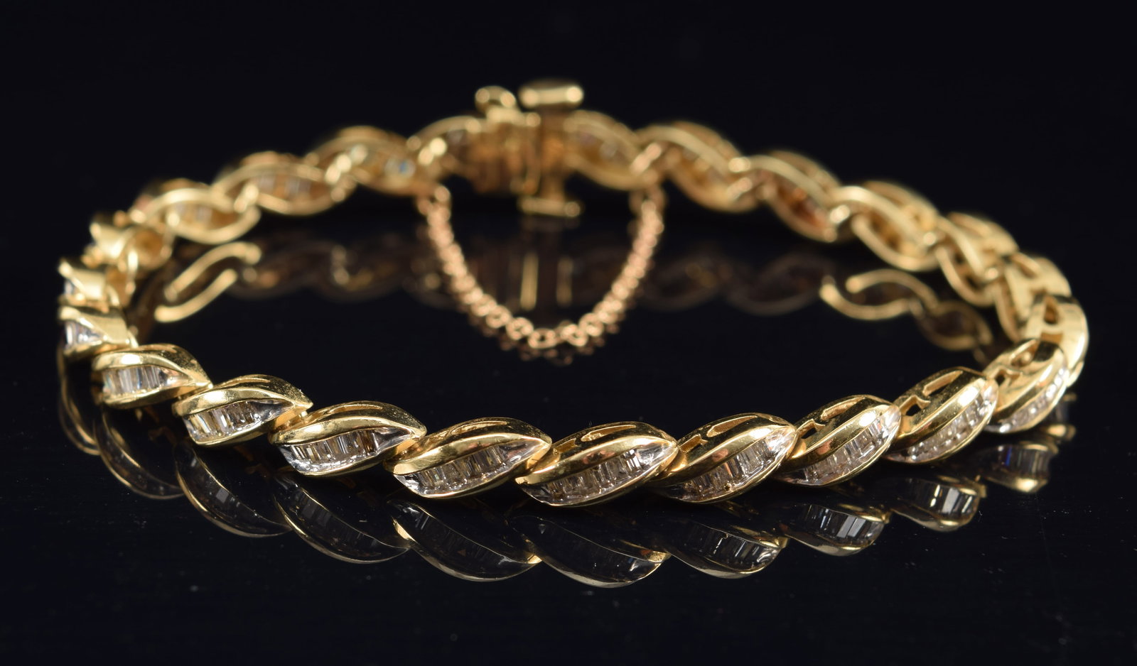 14K gold stylized braid design bracelet set with graduated baguette cut diamonds. Diameter when: 14K gold stylized braid design bracelet set with graduated baguette cut diamonds. Diameter when clasped: 2 1/8in. 15.5 grams.