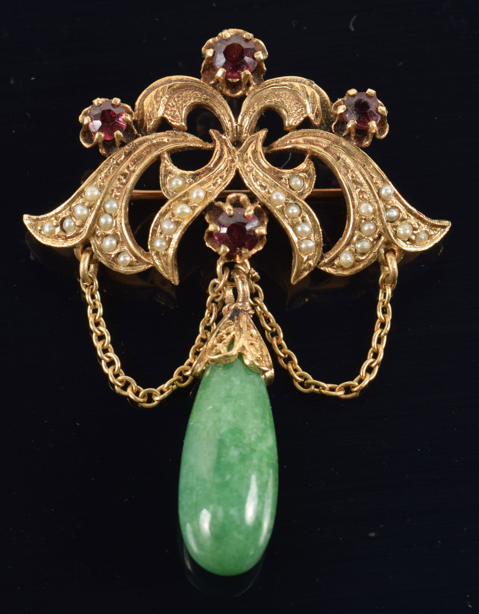 Antique 14K gold garnet and seed pearl pin with green jade drop pendant. Marked 14K on reverse. 1: Antique 14K gold garnet and seed pearl pin with green jade drop pendant. Marked 14K on reverse. 1 7/8in overall length. 8.2 grams.