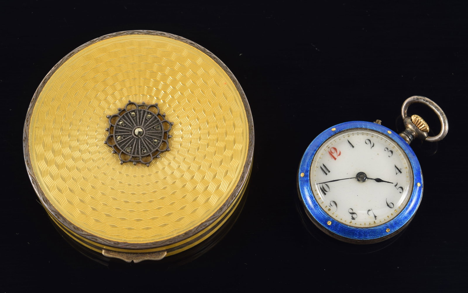 2 Enameled items, to include a sterling compact with yellow enamel engine work and a ladies pocket: 2 Enameled items, to include a sterling compact with yellow enamel engine work and a ladies pocket watch with bird and floral decorated back. Diameters 2 and 1 1/8 in.