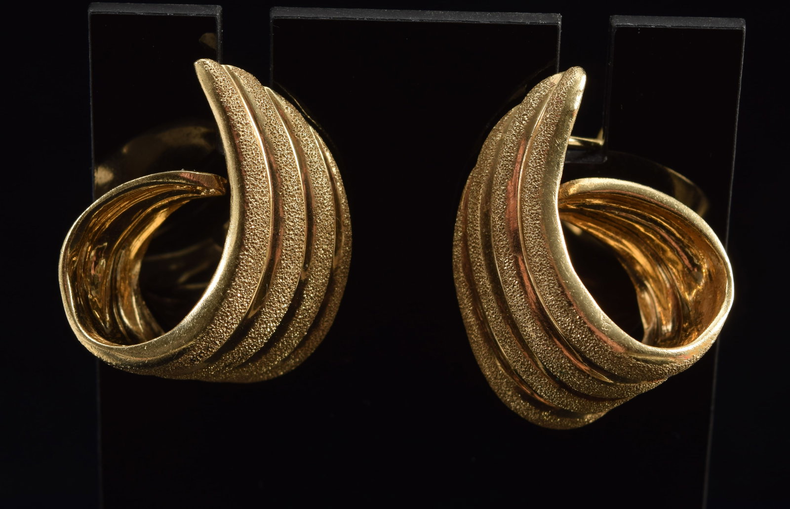 14K gold scrolling wing form earrings. Pattern of alternating polished and sandblasted textured: 14K gold scrolling wing form earrings. Pattern of alternating polished and sandblasted textured surfaces. Marked 14K. 0.75in length. 8.7 grams.