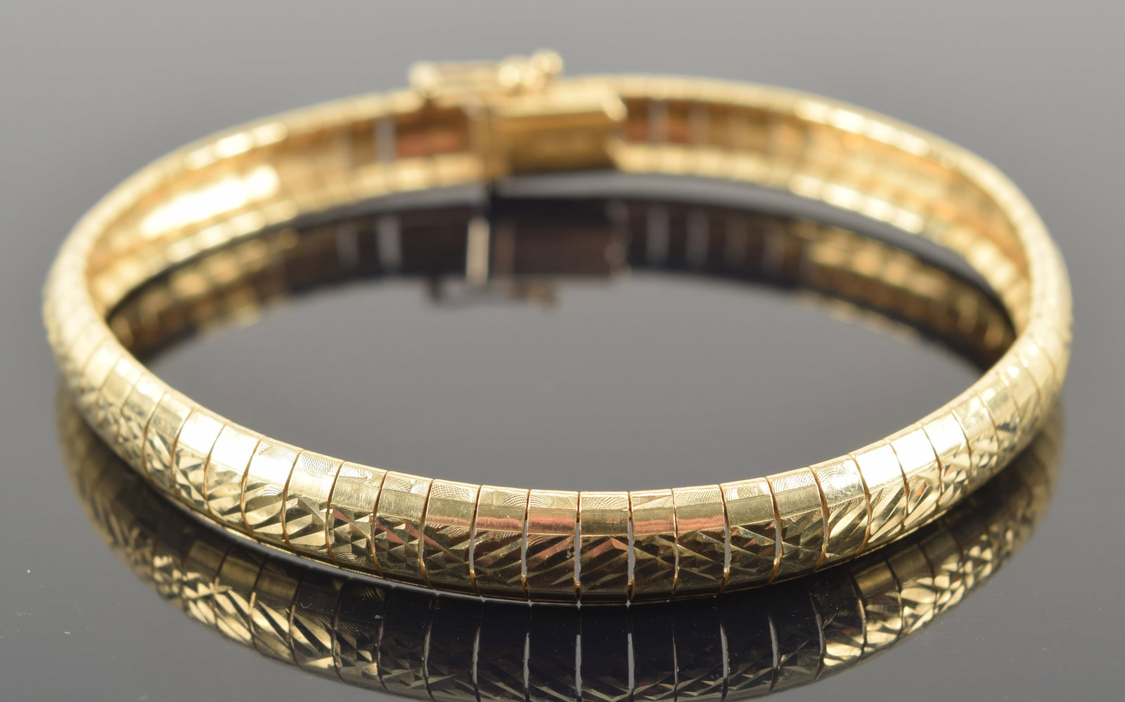 14K gold omega link bracelet with bright cut design. Clasp marked 14K Italy. 7.25in length. 13.7: 14K gold omega link bracelet with bright cut design. Clasp marked 14K Italy. 7.25in length. 13.7 grams.