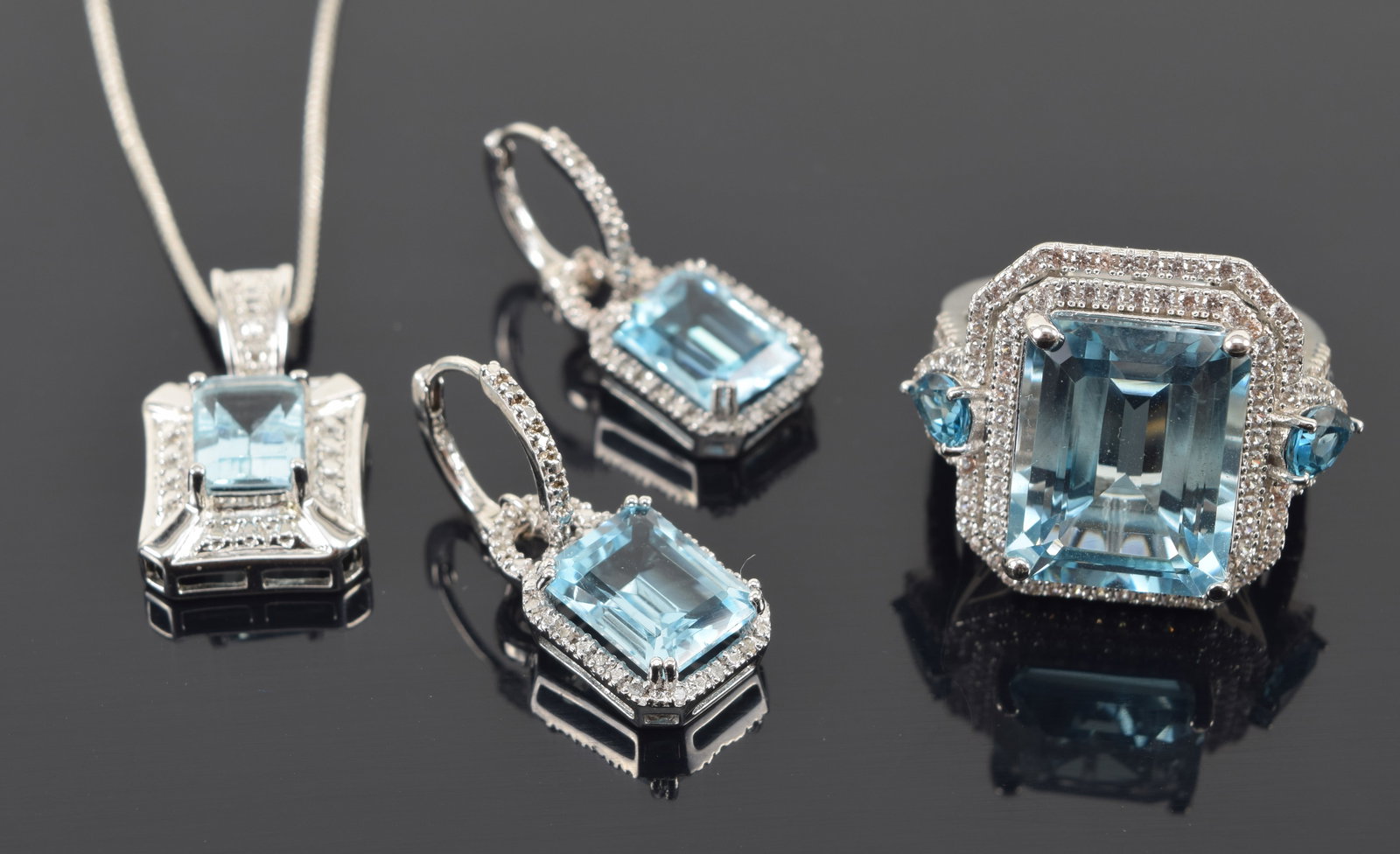Sterling silver blue topaz and diamond jewelry. 1) Ring with large emerald cut topaz measuring 15.1: Sterling silver blue topaz and diamond jewelry. 1) Ring with large emerald cut topaz measuring 15.1 x 11.9mm and surrounded by tiny diamonds and iolite. Ring size 8. Marked. 2) Pendant necklace with p