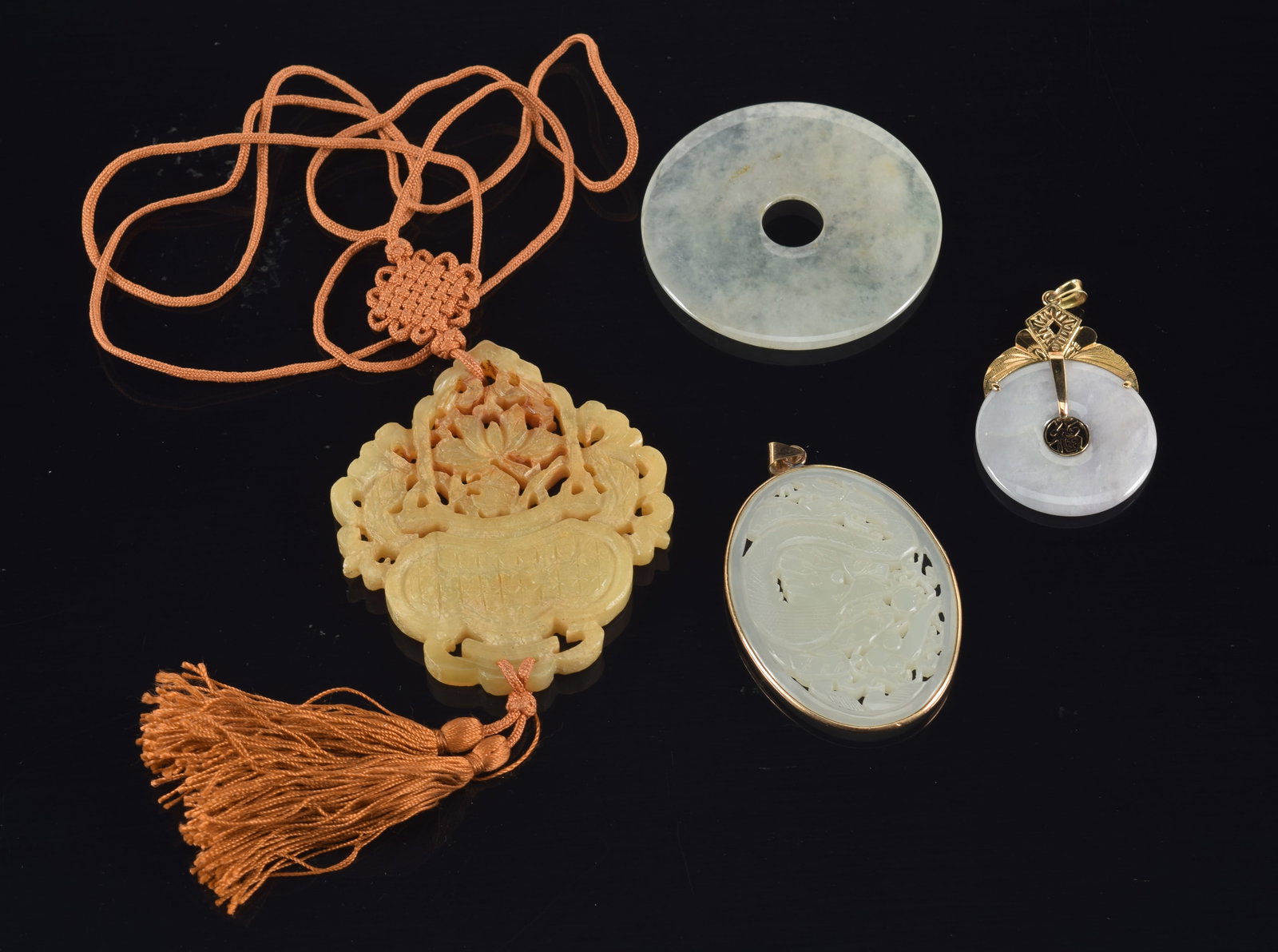 Gold jade jewelry and hardstone carvings. 1) 14K gold mounted lavender jade disc pendant. Marked 14K: Gold jade jewelry and hardstone carvings. 1) 14K gold mounted lavender jade disc pendant. Marked 14K HK. 2) 10K gold mounted reticulated dragon jade plaque pendant. Marked 10K. 3) Jade disc and hardst
