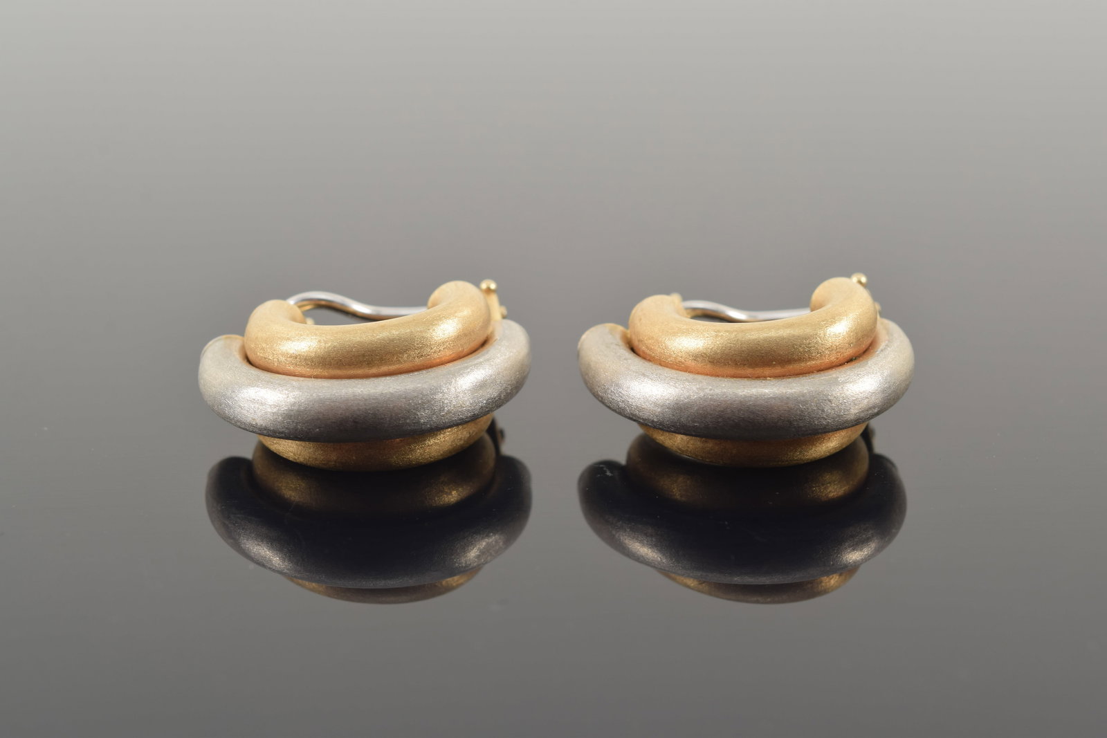14K white and yellow gold half-tube form earrings. Brushed finish. Clips marked. 7/8in length. 9.6: 14K white and yellow gold half-tube form earrings. Brushed finish. Clips marked. 7/8in length. 9.6 grams.