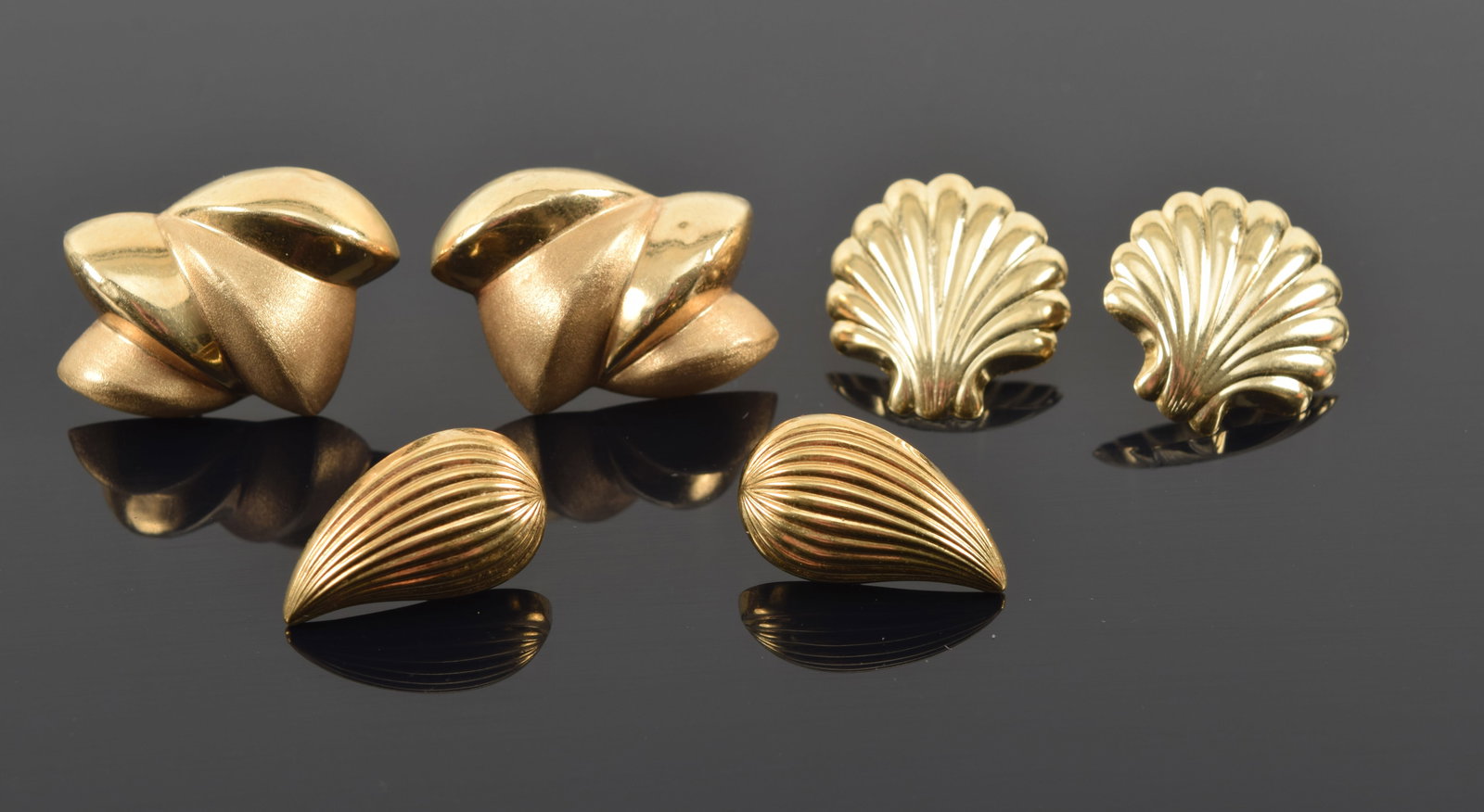 3 pairs of 14K gold earrings. Shell form, tear drop form, and abstract satin and polished pair. Each: 3 pairs of 14K gold earrings. Shell form, tear drop form, and abstract satin and polished pair. Each marked. 7.8 grams.