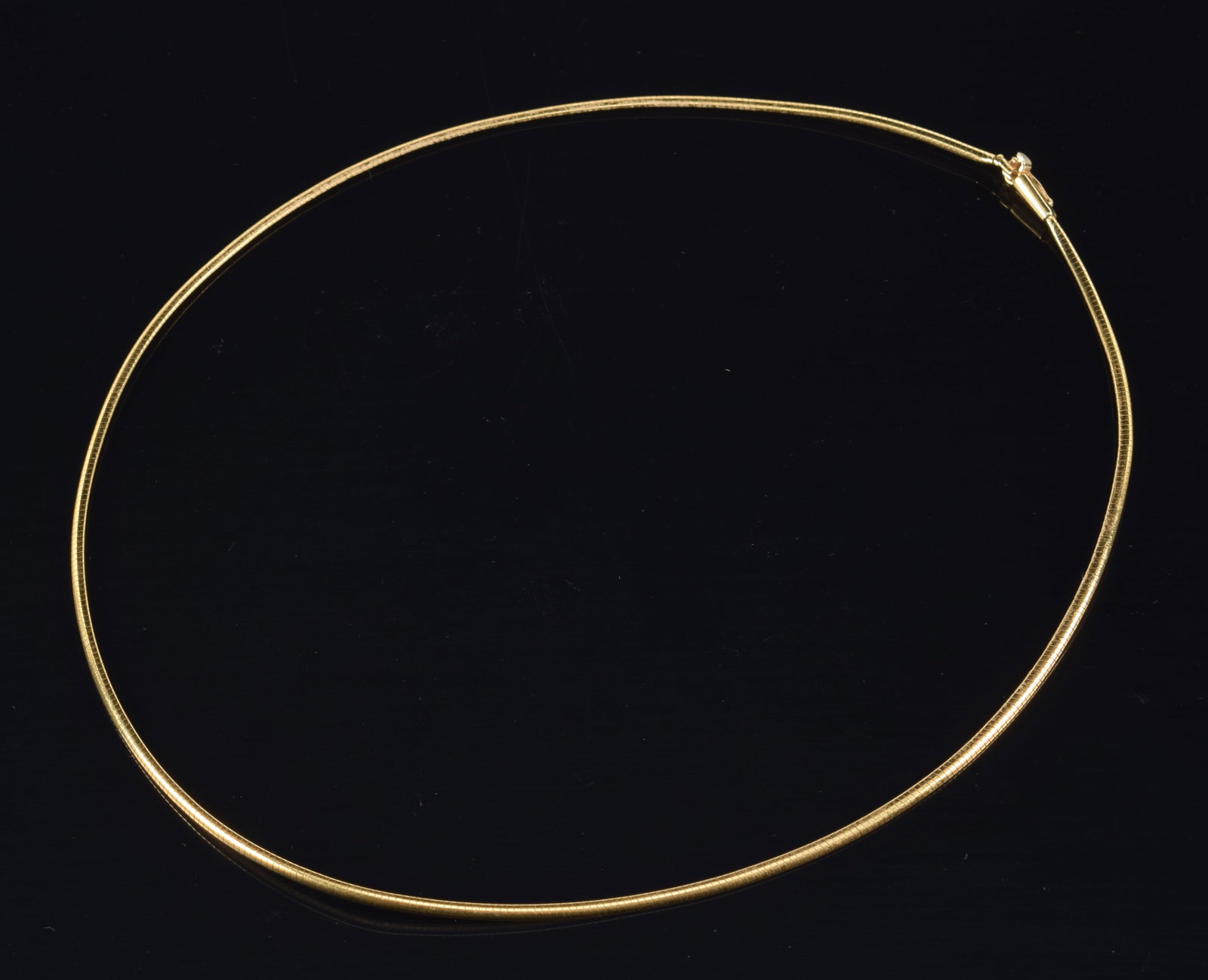 14K gold small omega link choker necklace. Clasp marked 14K Italy and maker's mark. Slight bend in: 14K gold small omega link choker necklace. Clasp marked 14K Italy and maker's mark. Slight bend in necklace. Approximately 17.5in length. 7.4 grams.