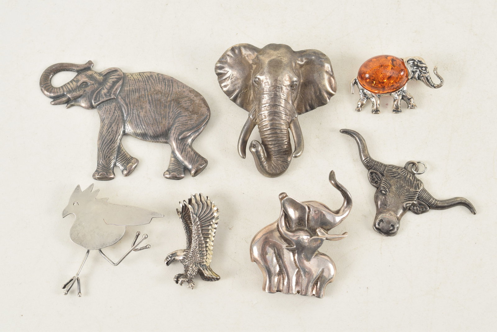 Lot of sterling silver figural animal form pins. Includes several elephants, eagle, bull head, and: Lot of sterling silver figural animal form pins. Includes several elephants, eagle, bull head, and running bird. Largest: 2.75in wide. 2.5 ozt total overall weight.