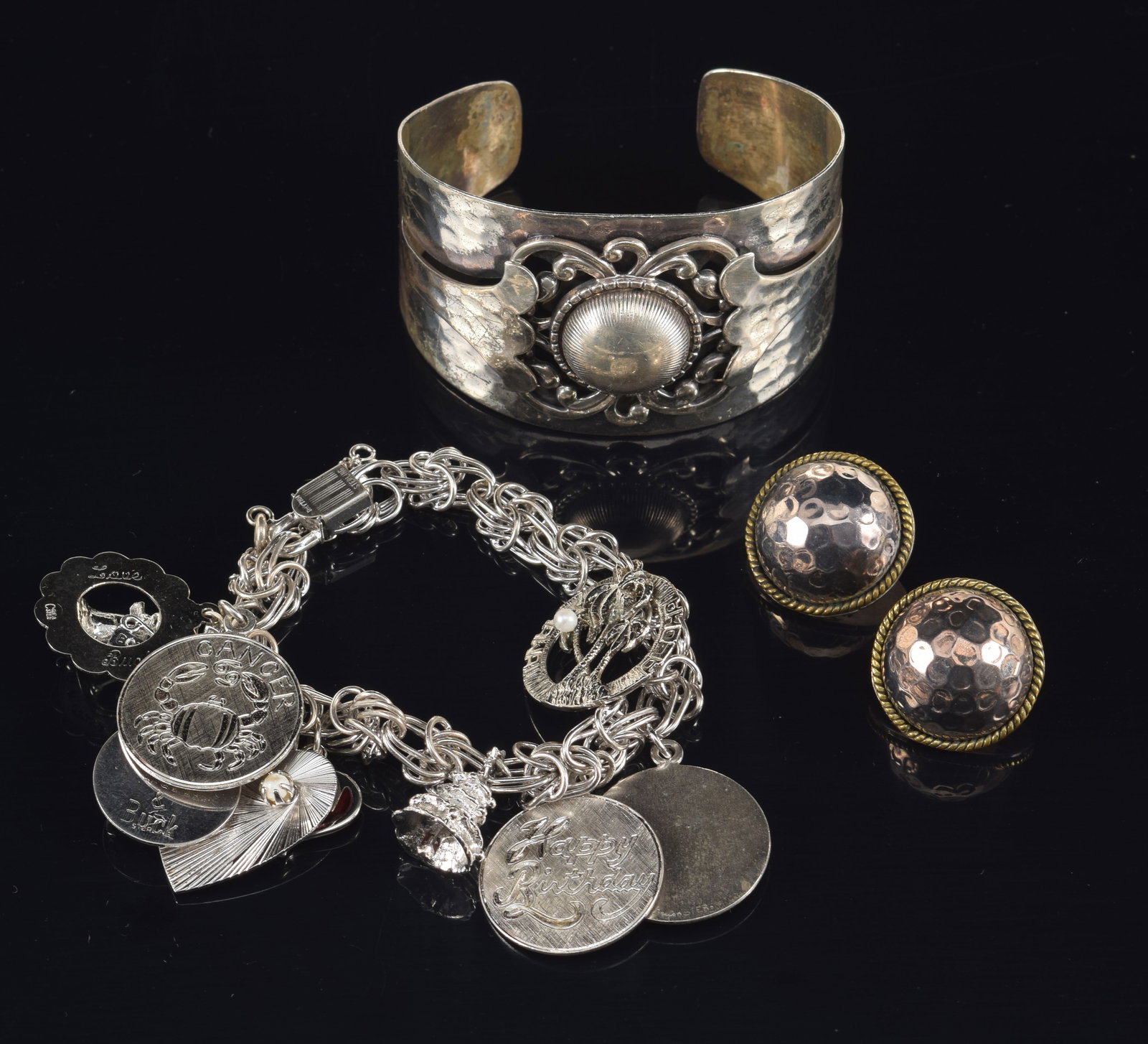 Selection of silver jewelry. To include: 1) Danecraft sterling silver cuff bracelet. 2) Mexican: Selection of silver jewelry. To include: 1) Danecraft sterling silver cuff bracelet. 2) Mexican silver domed earrings. 3) Sterling silver charm bracelet. 3.3 ozt total weight.