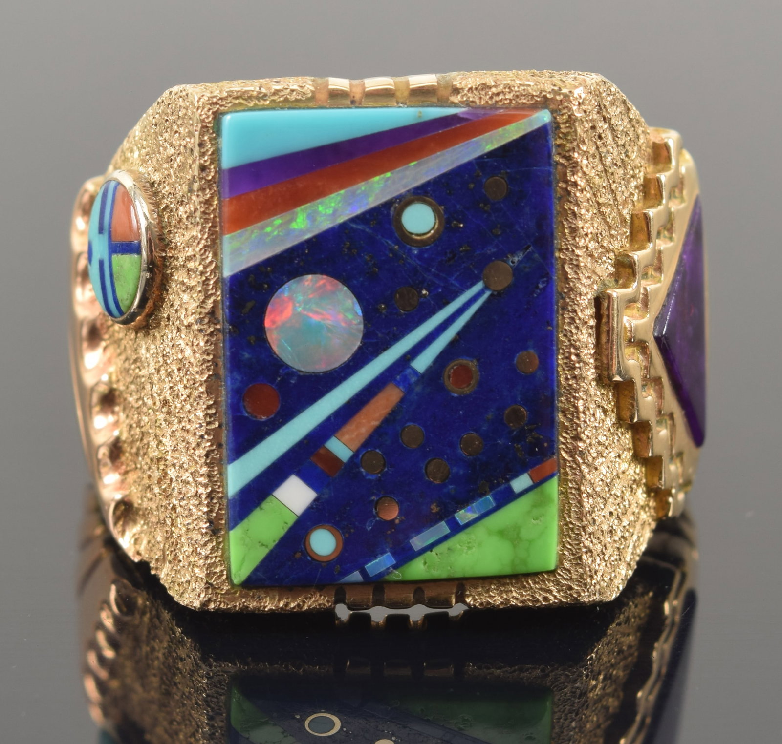 Jesse Monongya. Hopi-Dine. 14K gold inlaid "Cosmos" ring. Multi-stone inlaid astronomical scene with: Jesse Monongya. Hopi-Dine. 14K gold inlaid "Cosmos" ring. Multi-stone inlaid astronomical scene with stars, comets, and planets. Additional inlays on the sides. Relief and textured geometric setting. 