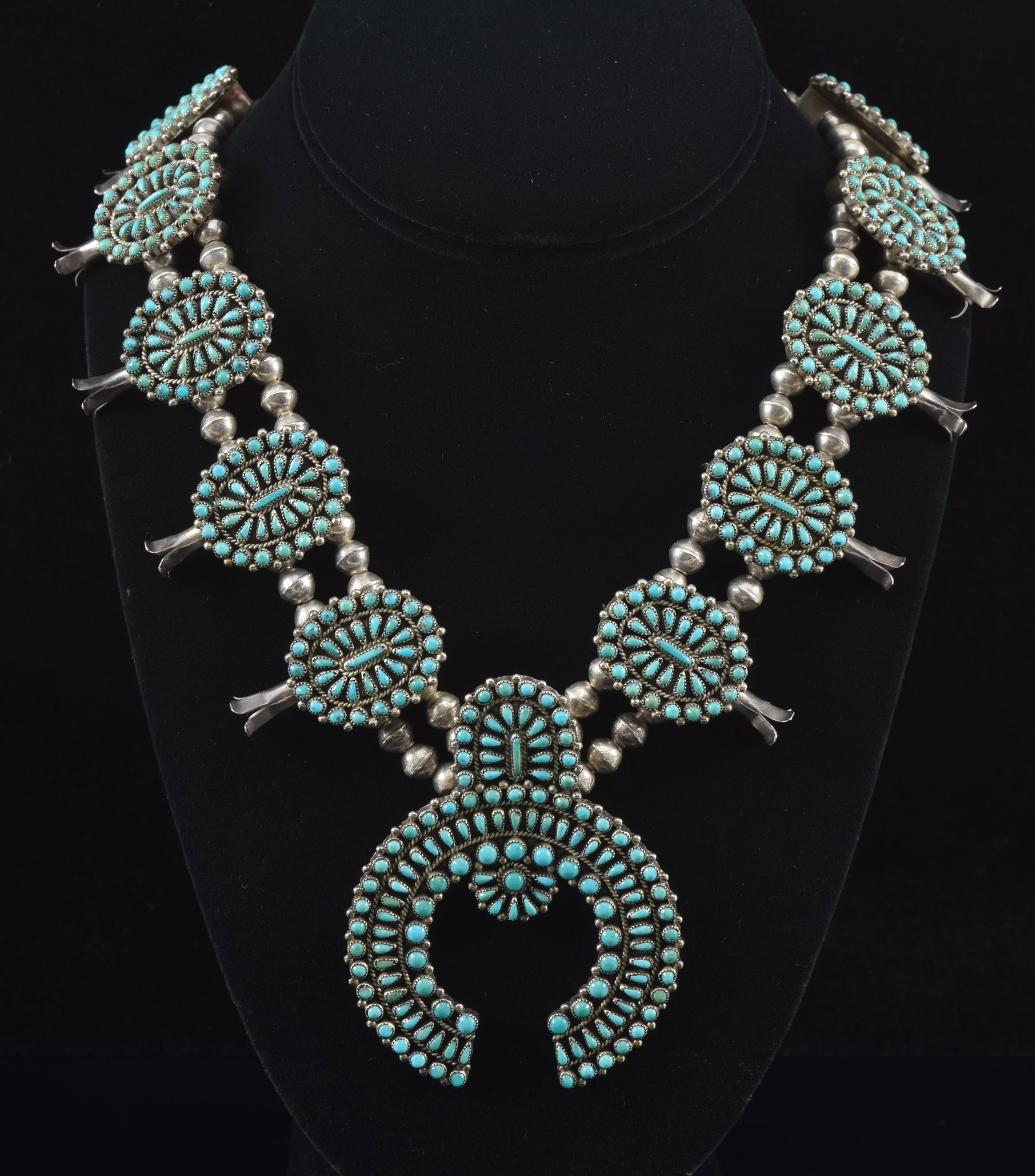 Southwest Zuni silver and turquoise squash blossom necklace. Intricate turquoise pave medallions and: Southwest Zuni silver and turquoise squash blossom necklace. Intricate turquoise pave medallions and pendant. Silver spherical beads. 22.5in length. 4.3 ozt.