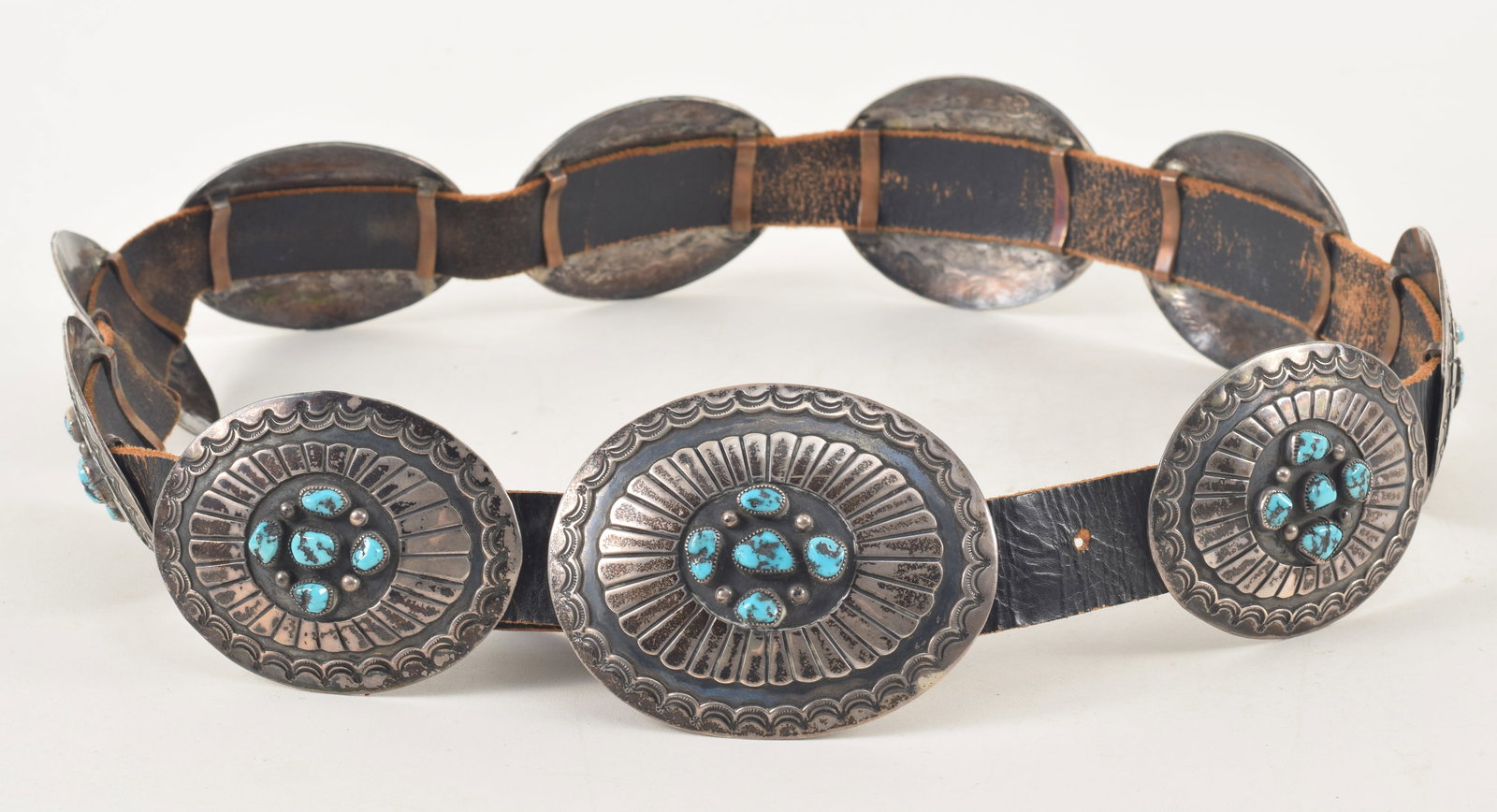 Vintage southwestern Native American silver and turquoise concho belt. Raised and recessed: Vintage southwestern Native American silver and turquoise concho belt. Raised and recessed decorations and engraved with borders of crescent moons. Largest (buckle): 3.5 x 2.75in; all others on belt: 
