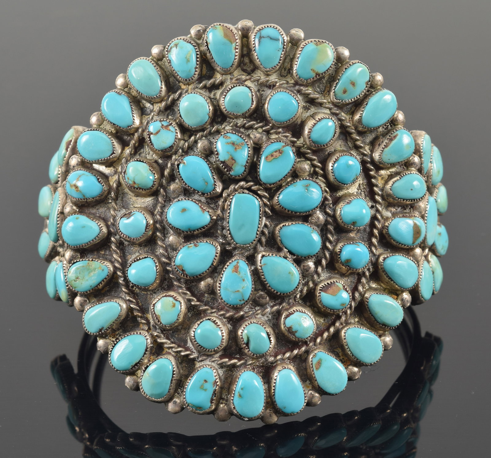 Vintage southwest Native American large silver and turquoise mounted cuff bracelet. Large concentric: Vintage southwest Native American large silver and turquoise mounted cuff bracelet. Large concentric turquoise design on top medallion flanked by semi-circle accents on sides. Appears unmarked. 2.6 oz