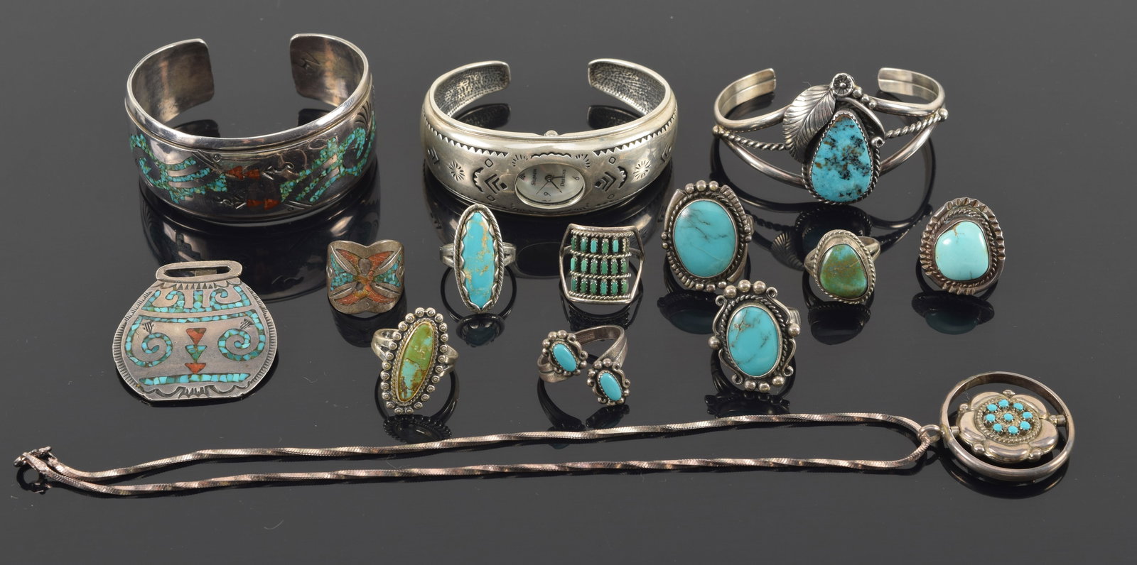 Selection of southwest Native American silver turquoise and coral jewelry. To include: 9 silver: Selection of southwest Native American silver turquoise and coral jewelry. To include: 9 silver rings set with turquoise and/or coral; Openwork cuff bracelet with feather decoration; mosaic inlaid cuf