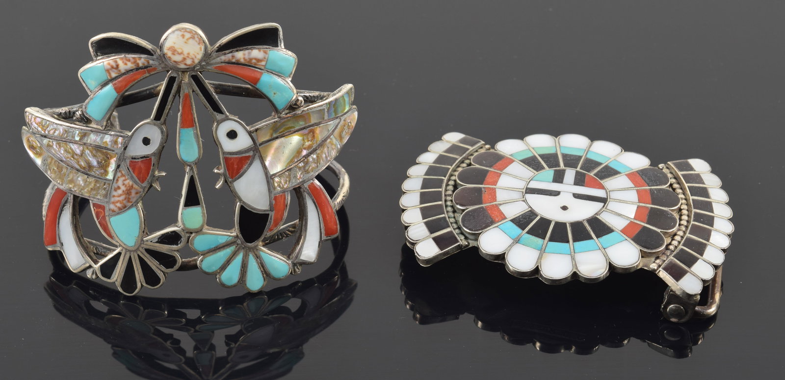 2 pieces of multi-stone inlaid southwest Native American silver jewelry. 1) J. D. Massie mask and: 2 pieces of multi-stone inlaid southwest Native American silver jewelry. 1) J. D. Massie mask and feather belt buckle, inlaid with turquoise, coral, mother of pearl, and onyx. Signed on reverse. 3in w