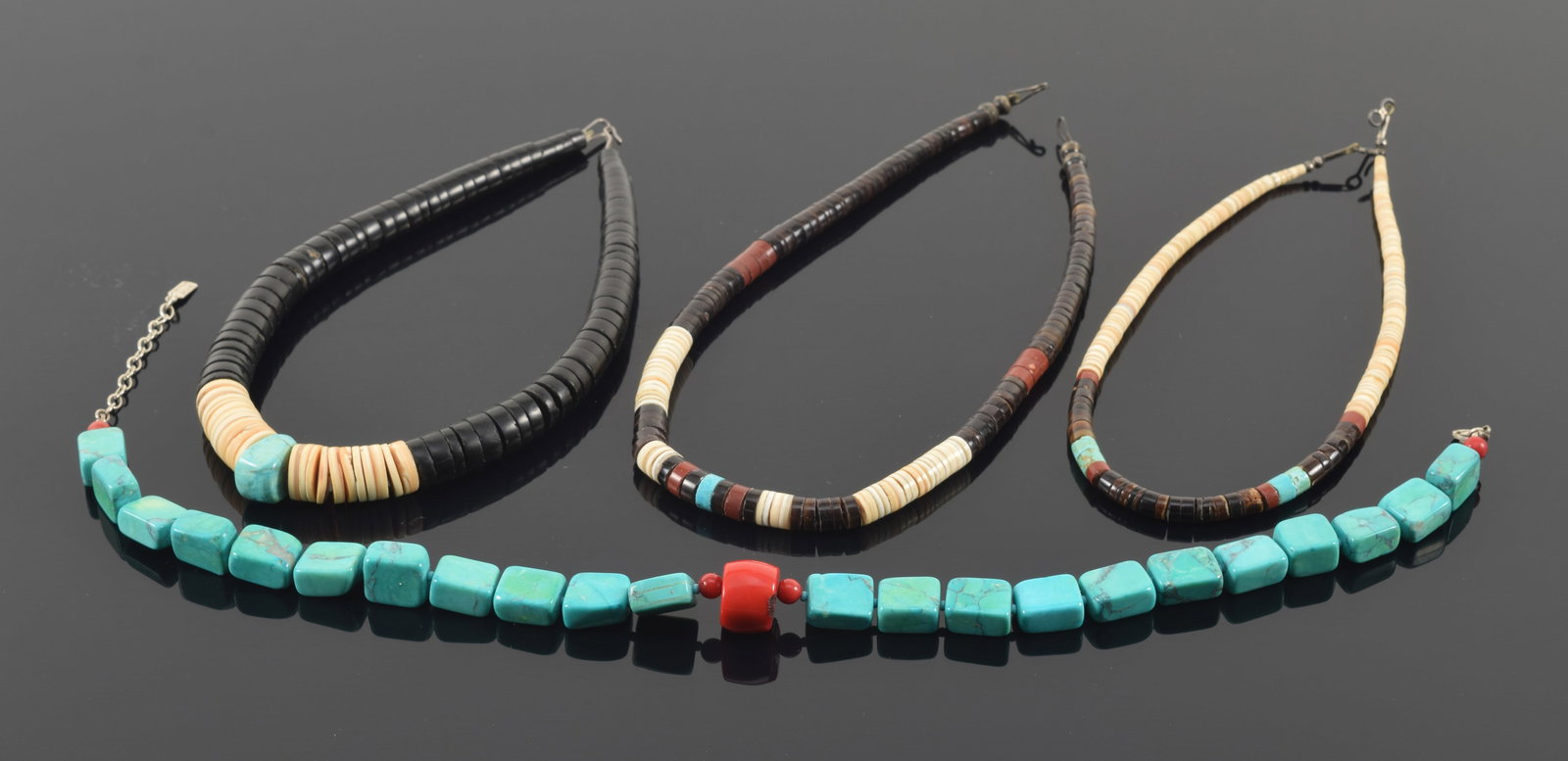 4 southwest style turquoise necklaces. 3 mounted with bone, horn and turquoise discs; 1 with cube: 4 southwest style turquoise necklaces. 3 mounted with bone, horn and turquoise discs; 1 with cube form turquoise stones and central coral bead. Each about 16in length.