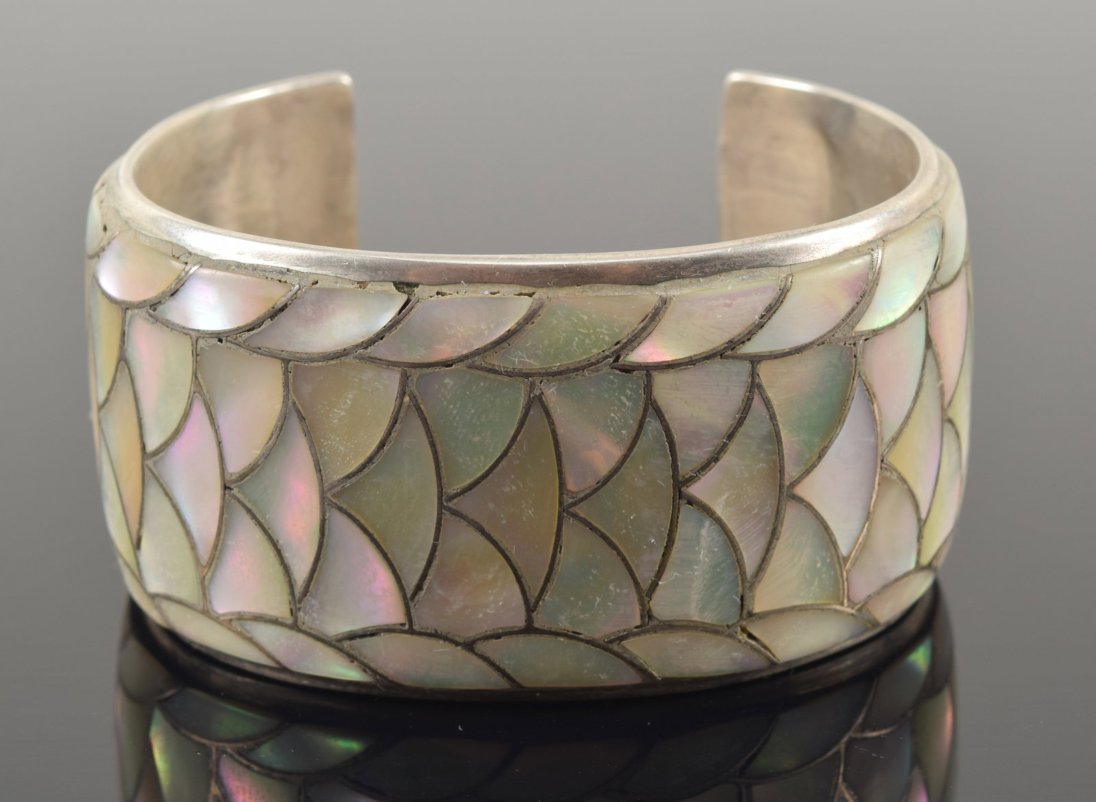 Orlinda Natewa Zuni sterling silver mother of pearl inlaid cuff bracelet. Scale design. Signed on: Orlinda Natewa Zuni sterling silver mother of pearl inlaid cuff bracelet. Scale design. Signed on interior of band. 2 5/8in wide. 2.2 ozt.