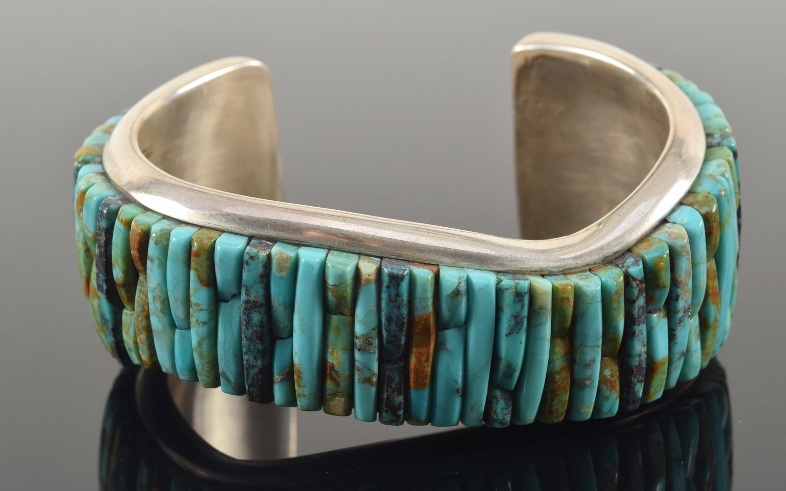 Pete Sierra southwest Native American sterling silver turquoise cuff bracelet. Wave form with mosaic: Pete Sierra southwest Native American sterling silver turquoise cuff bracelet. Wave form with mosaic of vertical turquoise stones. Marked on interior. 3 1/8in wide. 3.4 ozt.