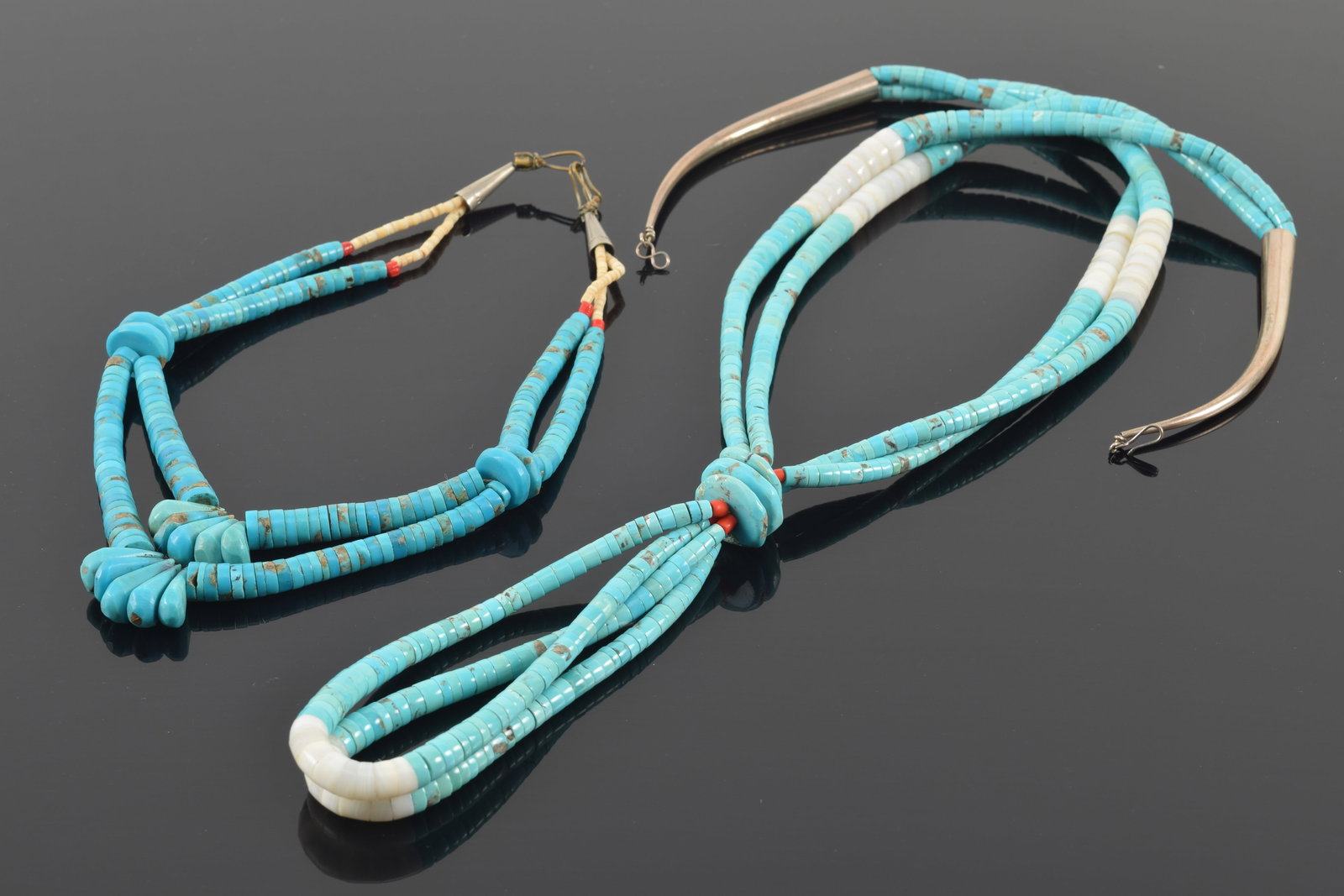 2 Southwest Native American turquoise and silver necklaces. 1) Large turquoise, coral and white: 2 Southwest Native American turquoise and silver necklaces. 1) Large turquoise, coral and white stone disc multi-strand necklace with bunched pendant. 29in length. 2) Dual strand turquoise disc neckla