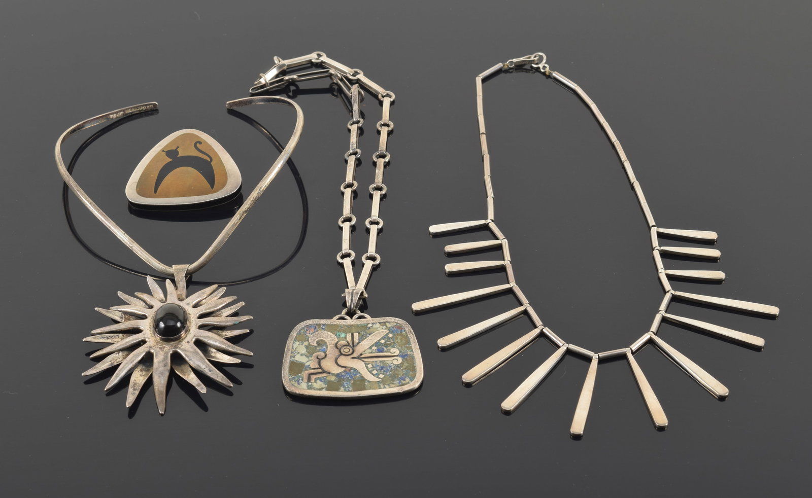 Lot of Mexican silver jewelry. 1) Stella Popowski mixed metal and enamel cat or animal pin. Marked: Lot of Mexican silver jewelry. 1) Stella Popowski mixed metal and enamel cat or animal pin. Marked on reverse. 2in wide. 2) Mexican sterling silver large sunburst pendant necklace. 3) Emma Melendez Ta