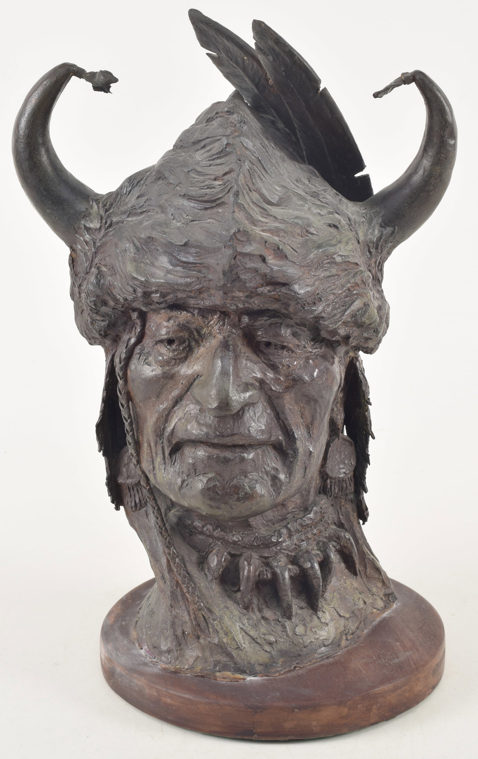 George Phippen. American. Bronze bust of an American Indian warrior with horned and feathered: George Phippen. American. Bronze bust of an American Indian warrior with horned and feathered headdress. Signed on reverse of neck. Numbered 9/20. 13in high.