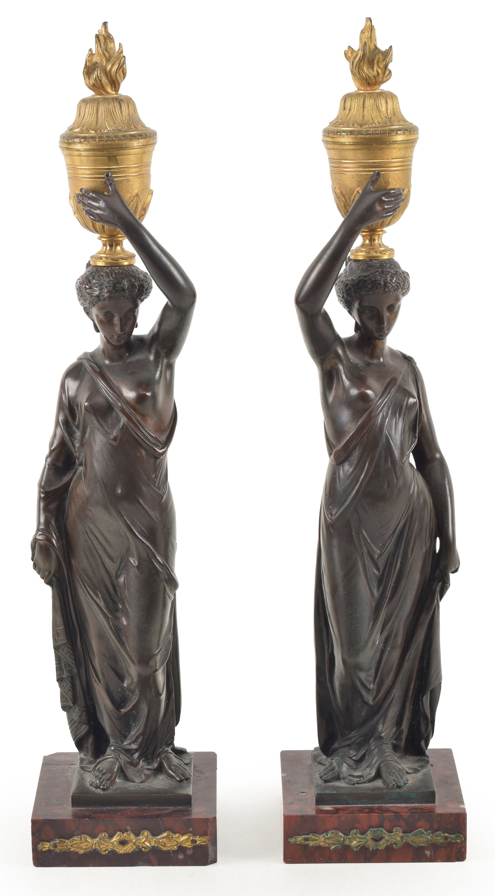 A pair of French bronze figures of maidens holding ormolu urns on their heads, on colored marble: A pair of French bronze figures of maidens holding ormolu urns on their heads, on colored marble bases, 19th Century. Fine old patina, damage to back of one marble base. Height 19 1/2 in.