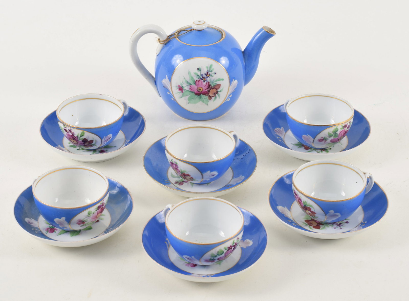 19th century Russian porcelain tea set with 6 cups and saucers. Royal blue ground with hand painted: 19th century Russian porcelain tea set with 6 cups and saucers. Royal blue ground with hand painted floral vignettes. Marked on base. Several saucers with restoration. Teapot: 7.25in wide.