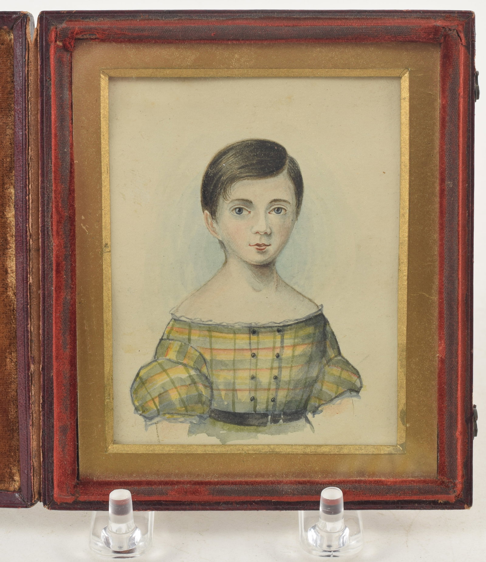 Early 19th Century finely executed portrait of a girl with short hair and bright plaid empire dress: Early 19th Century finely executed portrait of a girl with short hair and bright plaid empire dress with belted waist. Watercolor on paper in leather bound folding frame. Image size 3 3/4 x 2 3/4 in. 