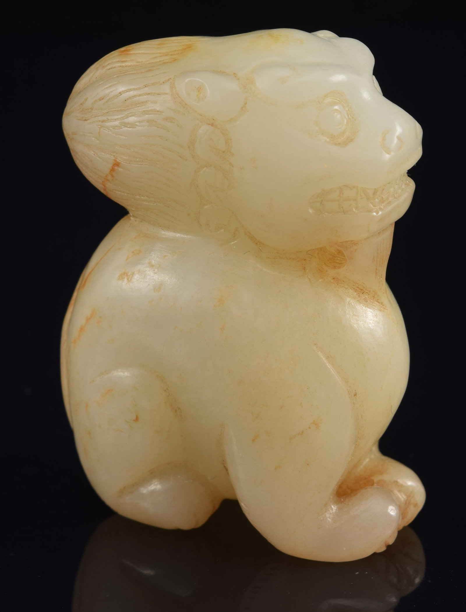 Jade carving of a buddhist lion. China. 19th century or earlier. Stone of a white color with russet: Jade carving of a buddhist lion. China. 19th century or earlier. Stone of a white color with russet markings. 1.75in.