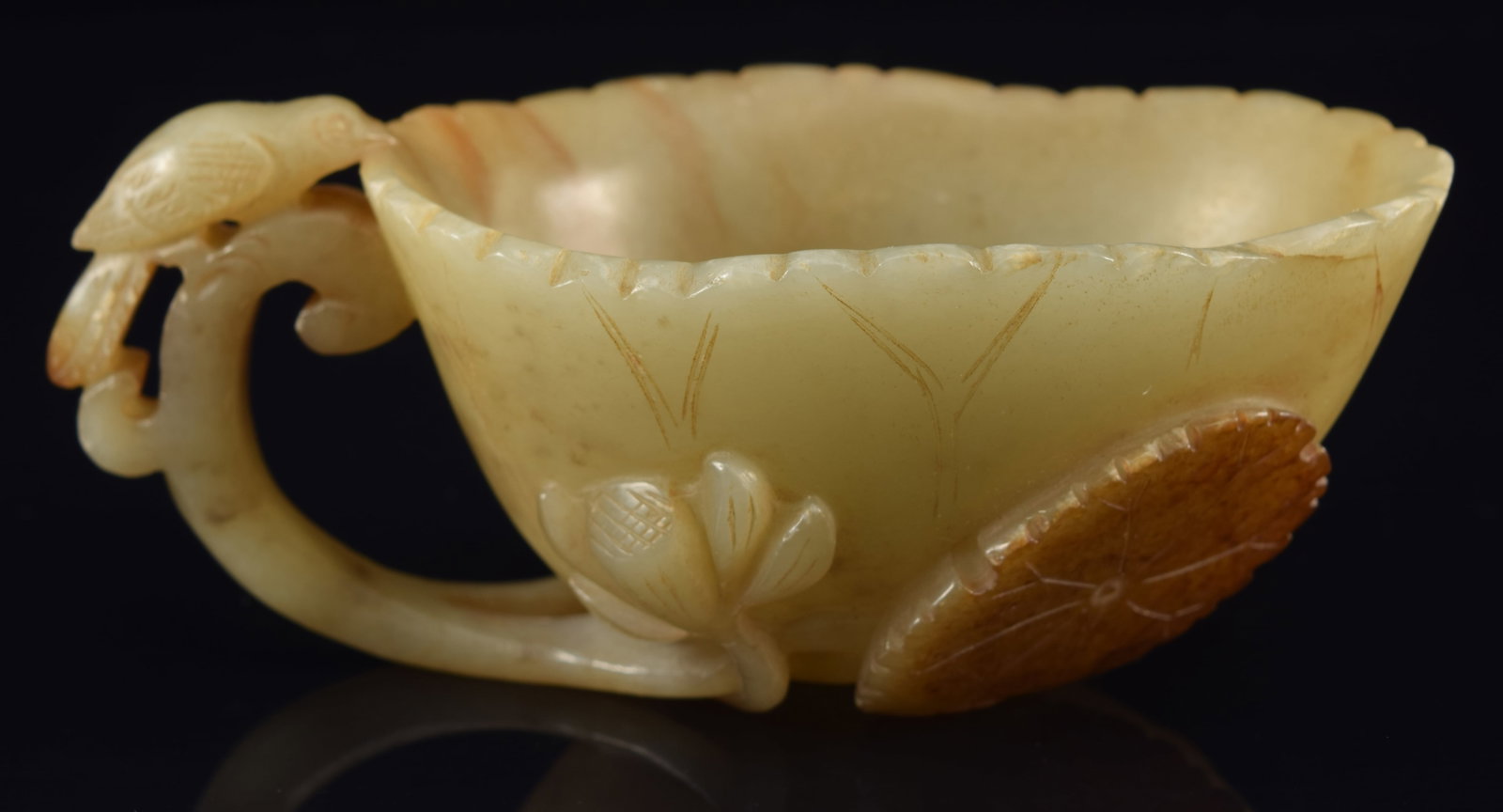 Wine cup. China. Ming period (1368-1644) or earlier. Celadon stone with russet markings. Carved as a (1 of 7)