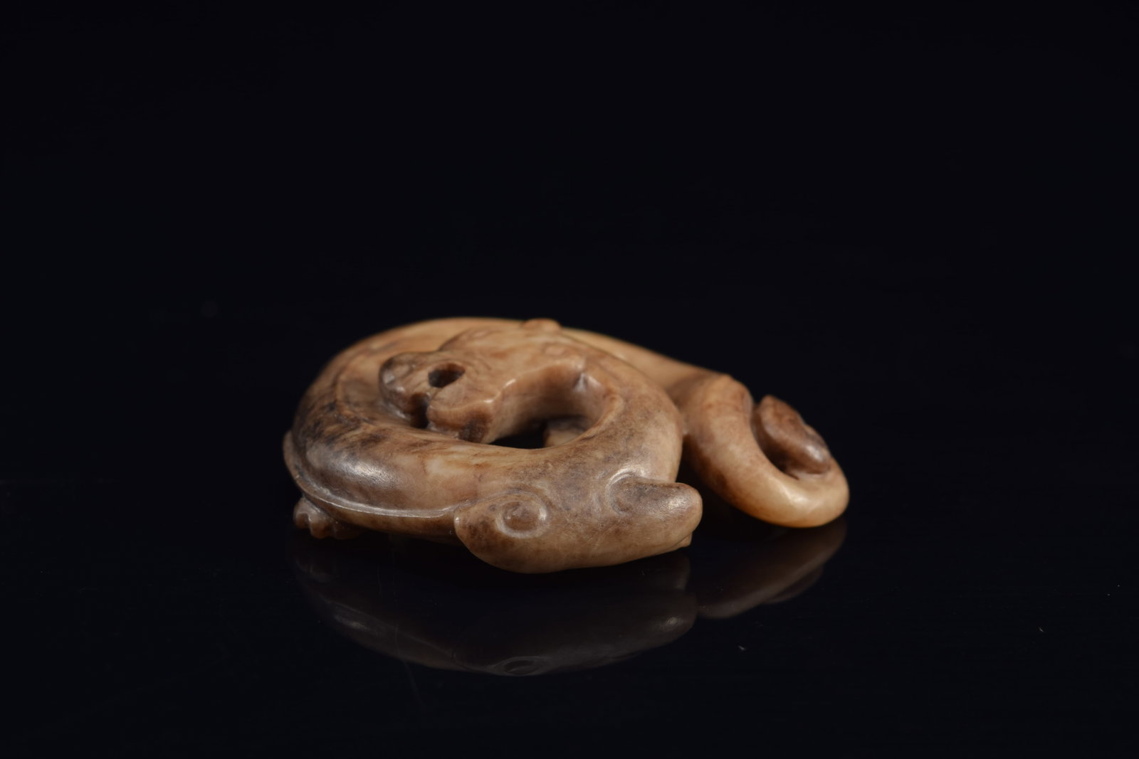 Jade pendant. China. Liao period. Brownish colored jade carved in a roundel as a dragon. 1.5in. - 2