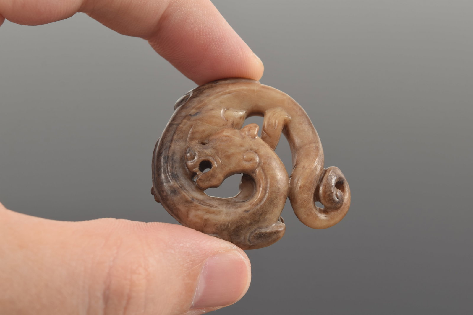 Jade pendant. China. Liao period. Brownish colored jade carved in a roundel as a dragon. 1.5in. - 4