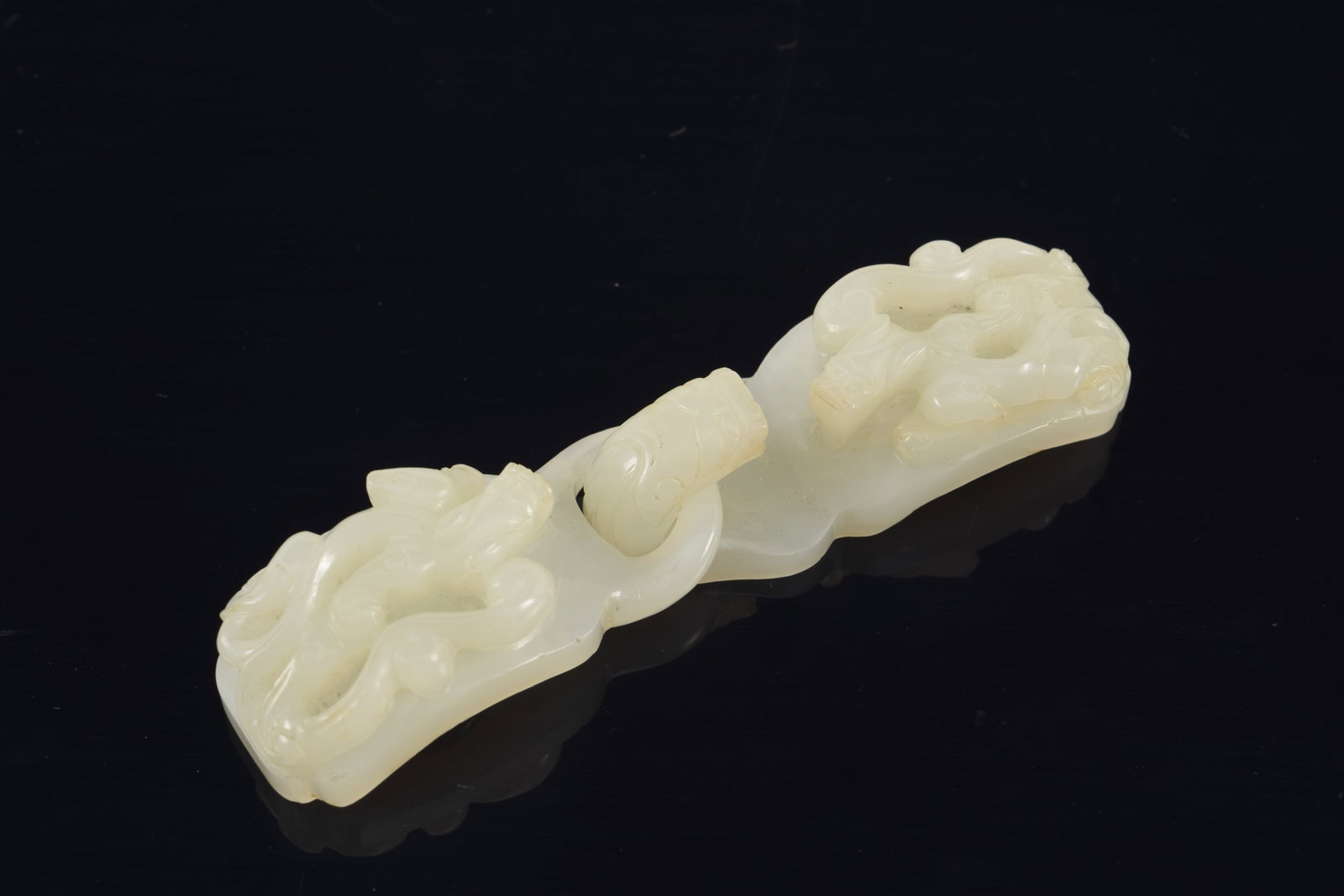 White jade buckle. China. 19th century. Carved with dragons. 3 5/8in length. (1 of 4)