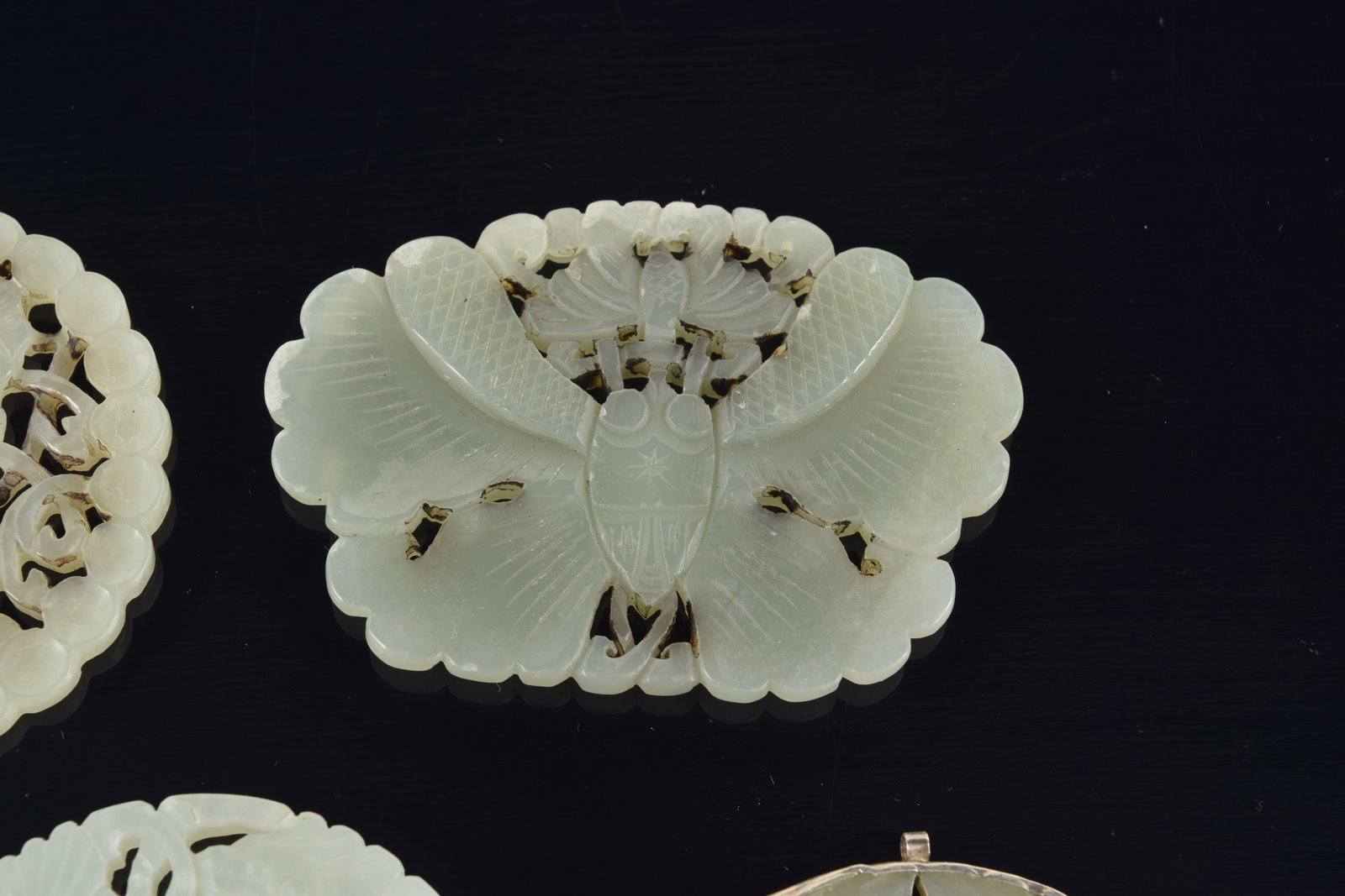 4 jade pendants. China. 19th to early 20th century. One silver mounted. 3in. - 3