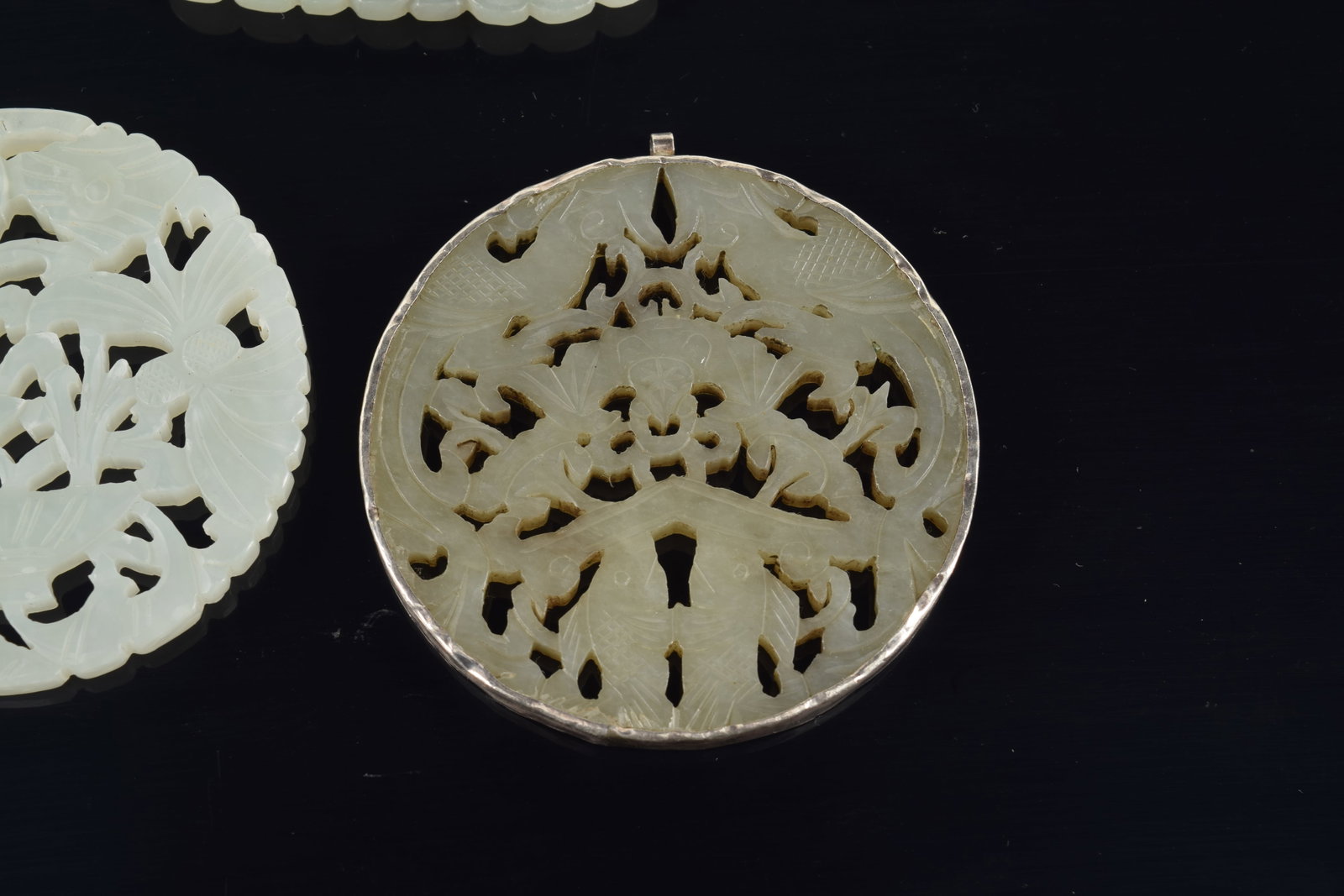 4 jade pendants. China. 19th to early 20th century. One silver mounted. 3in. - 5