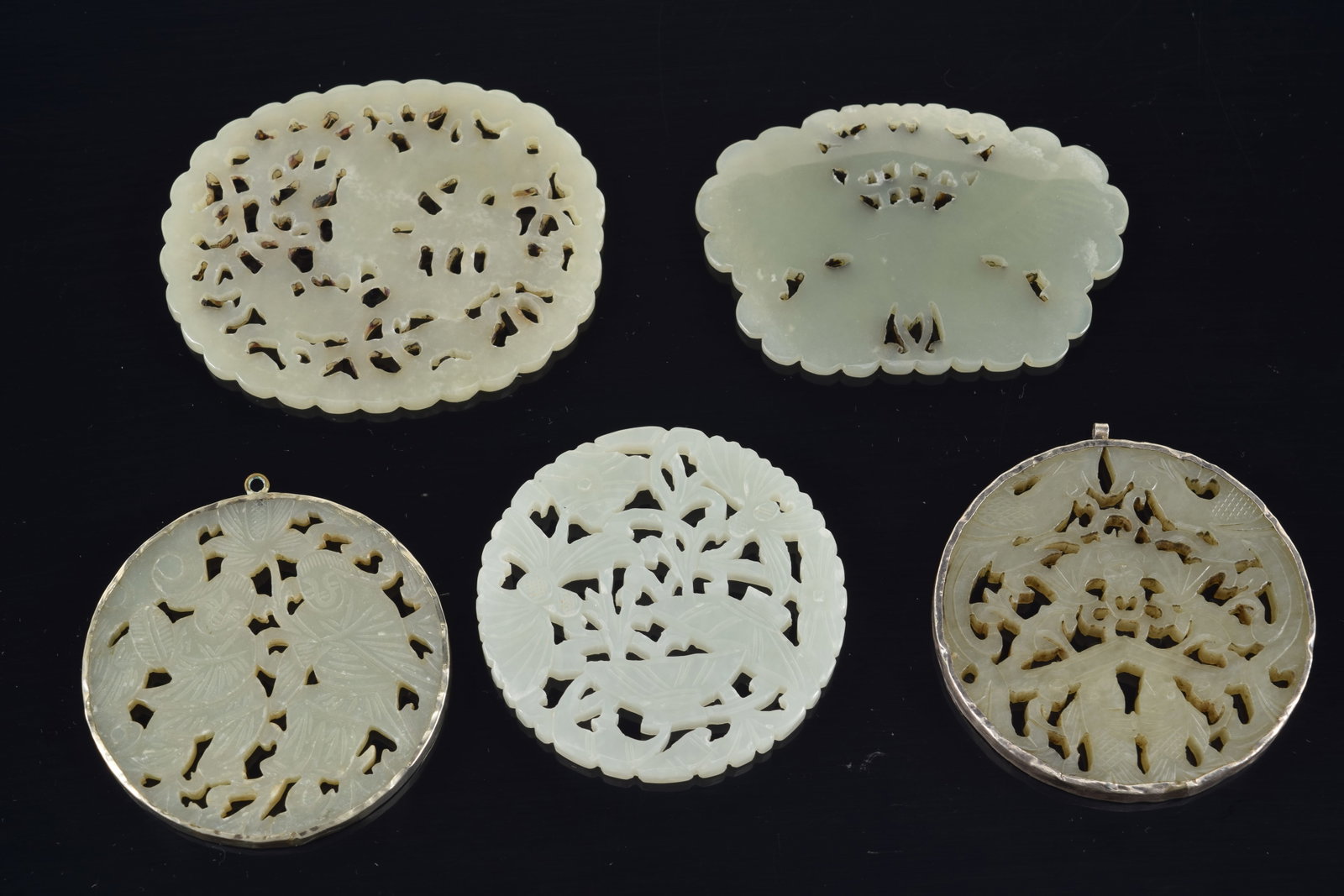 4 jade pendants. China. 19th to early 20th century. One silver mounted. 3in. - 7