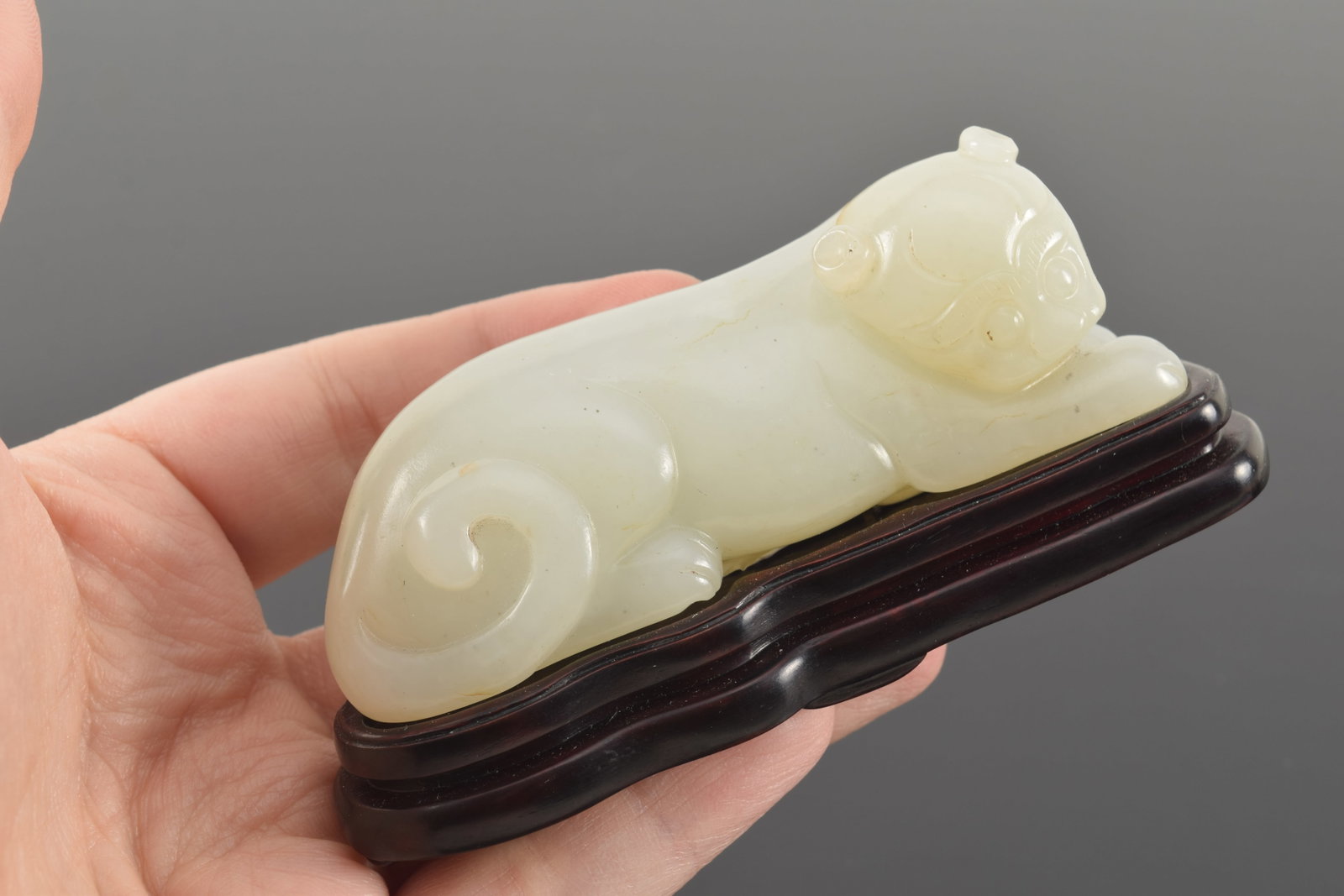 Jade tiger. Pure white color. China. 18th century. Fitted stand. 3.5in length. - 5