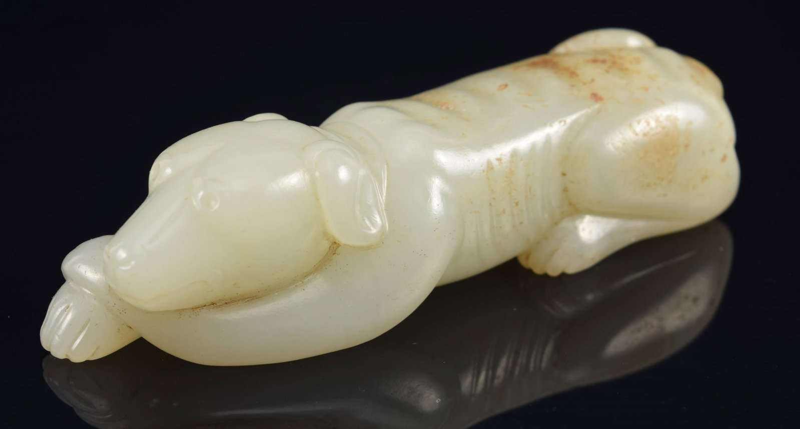 Reclining greyhound. China. 18th century. Celadon covered jade. 3.5in length.: Reclining greyhound. China. 18th century. Celadon covered jade. 3.5in length.