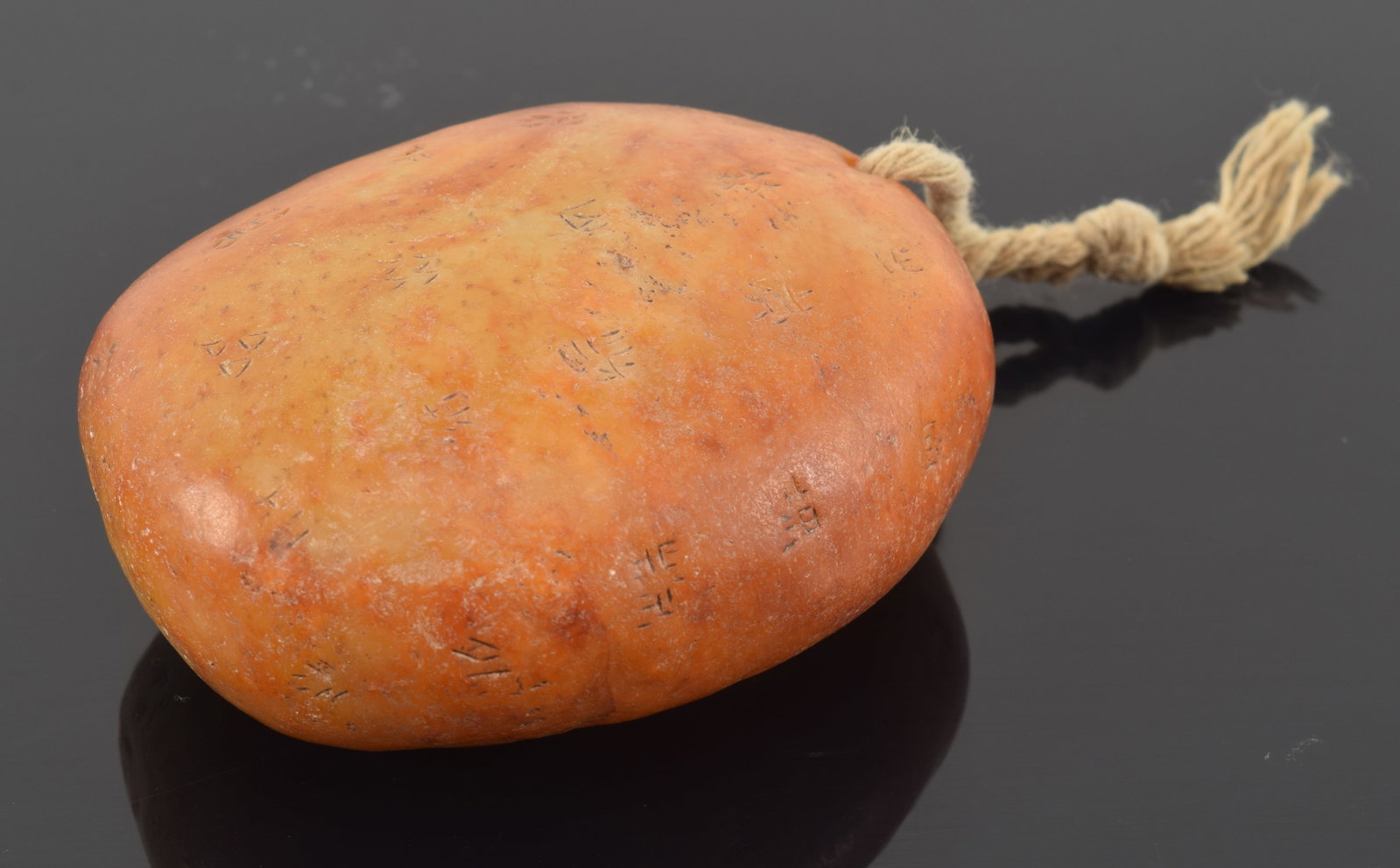 Large jade pebble. China. Orange skin intact. Surface engraved with Chinese characters. 3in. (1 of 4)