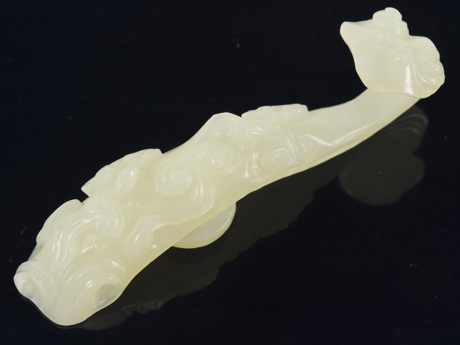 Jade garment hook. China. 19th century. Surface carved with ling chih. 3.25in length. (1 of 6)