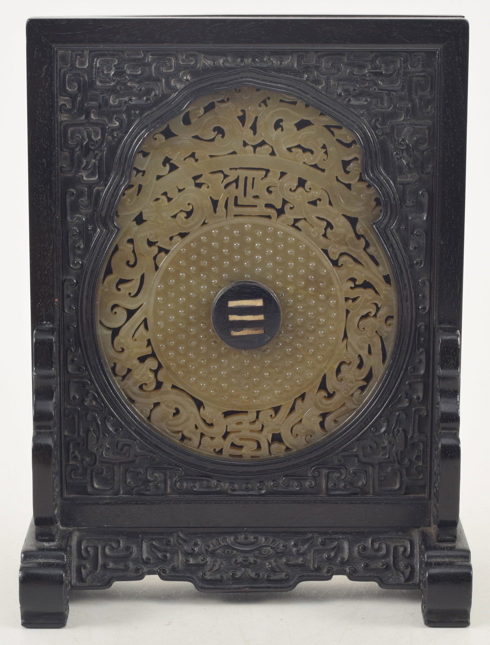 Jade table screen. China. 18th century. Chien Lung inscription on the back. Carved jade pi with a: Jade table screen. China. 18th century. Chien Lung inscription on the back. Carved jade pi with a central zitan button labeled san. 9.25 x 7in.