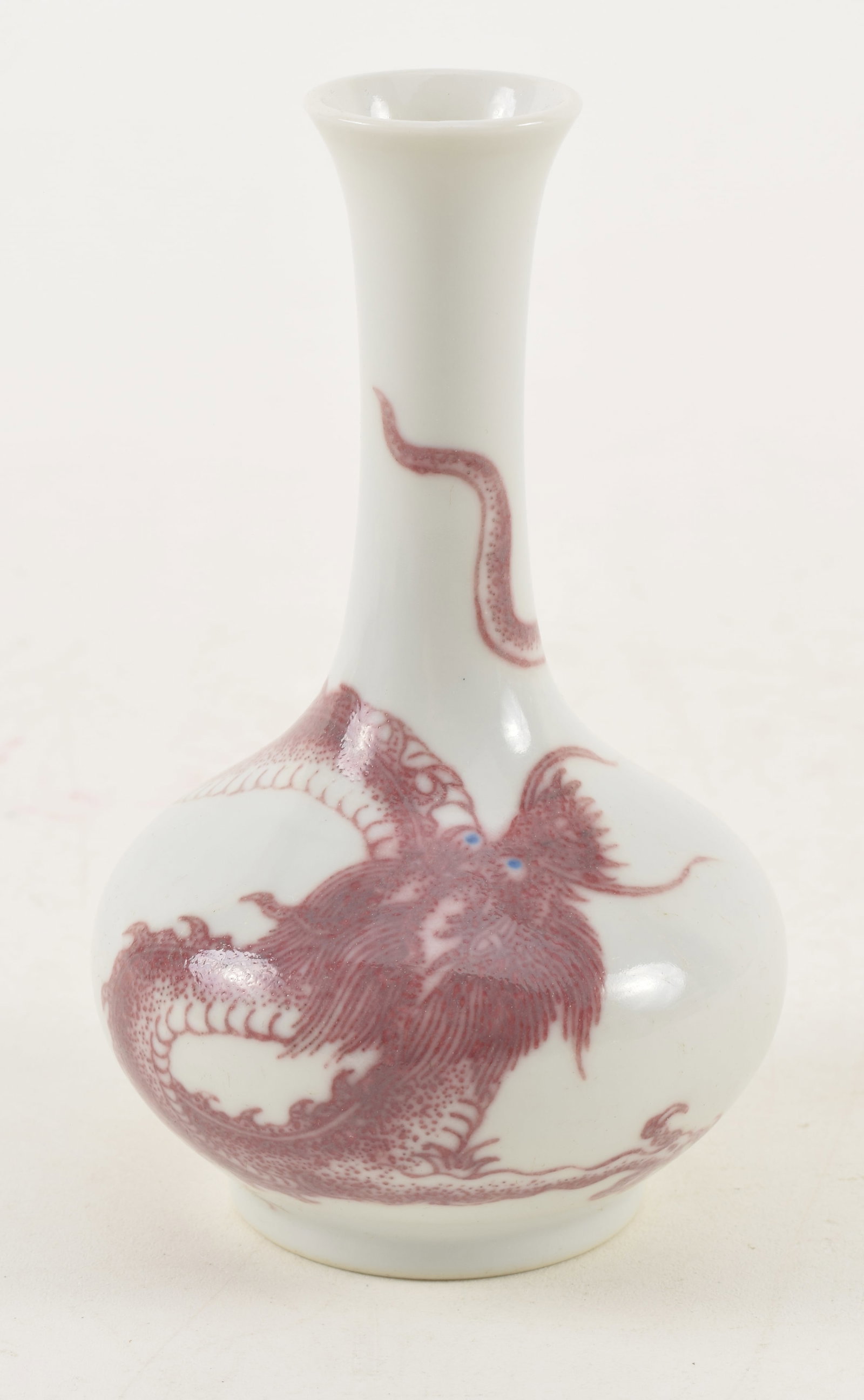 20th century Chinese porcelain underglaze red dragon decorated small vase. Underglaze blue eyes.: 20th century Chinese porcelain underglaze red dragon decorated small vase. Underglaze blue eyes. Bottle form. 4.5in high.