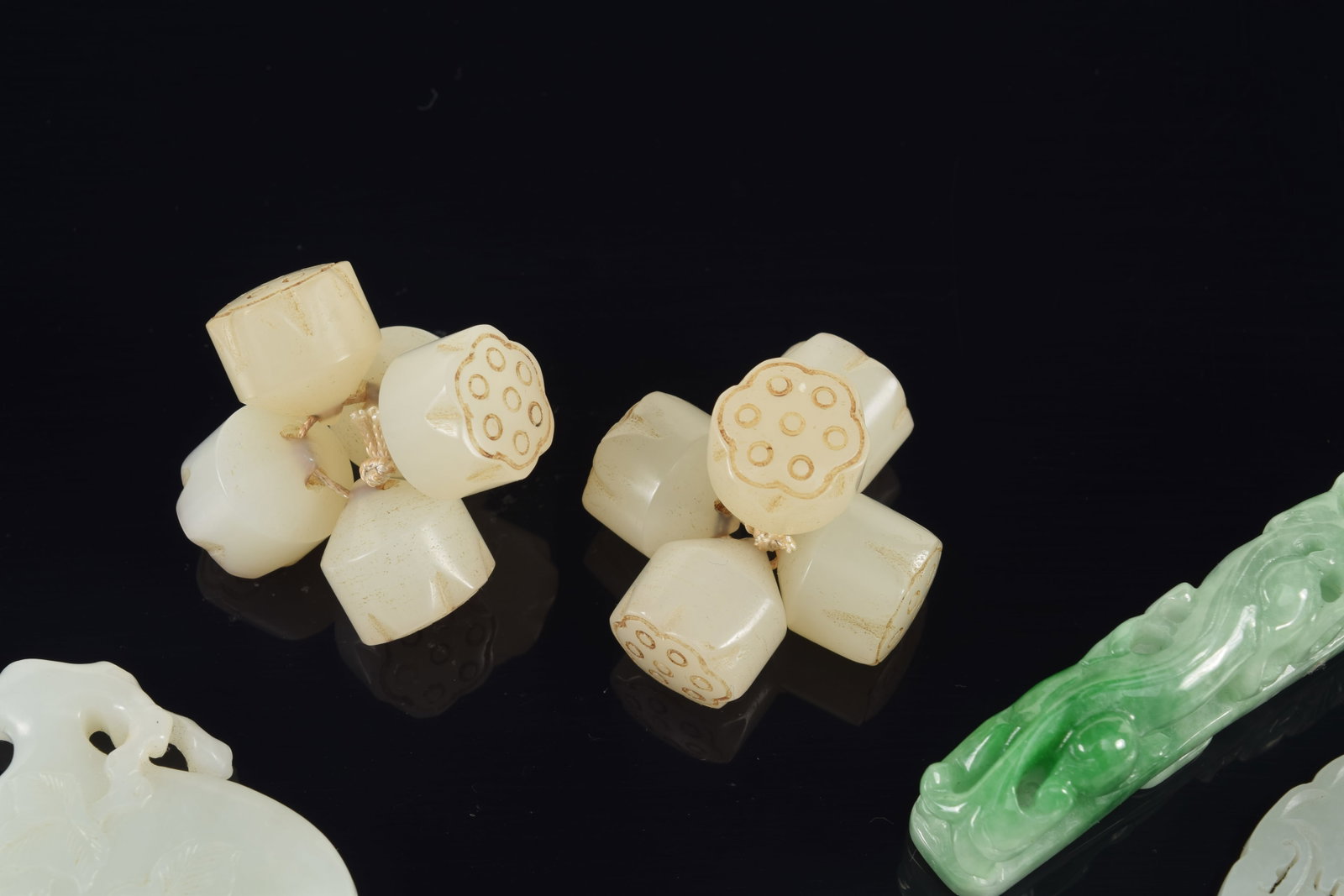 4 jade pendants. China. 19th century. Together with a group of jade lotus beads. Largest 3in. - 2