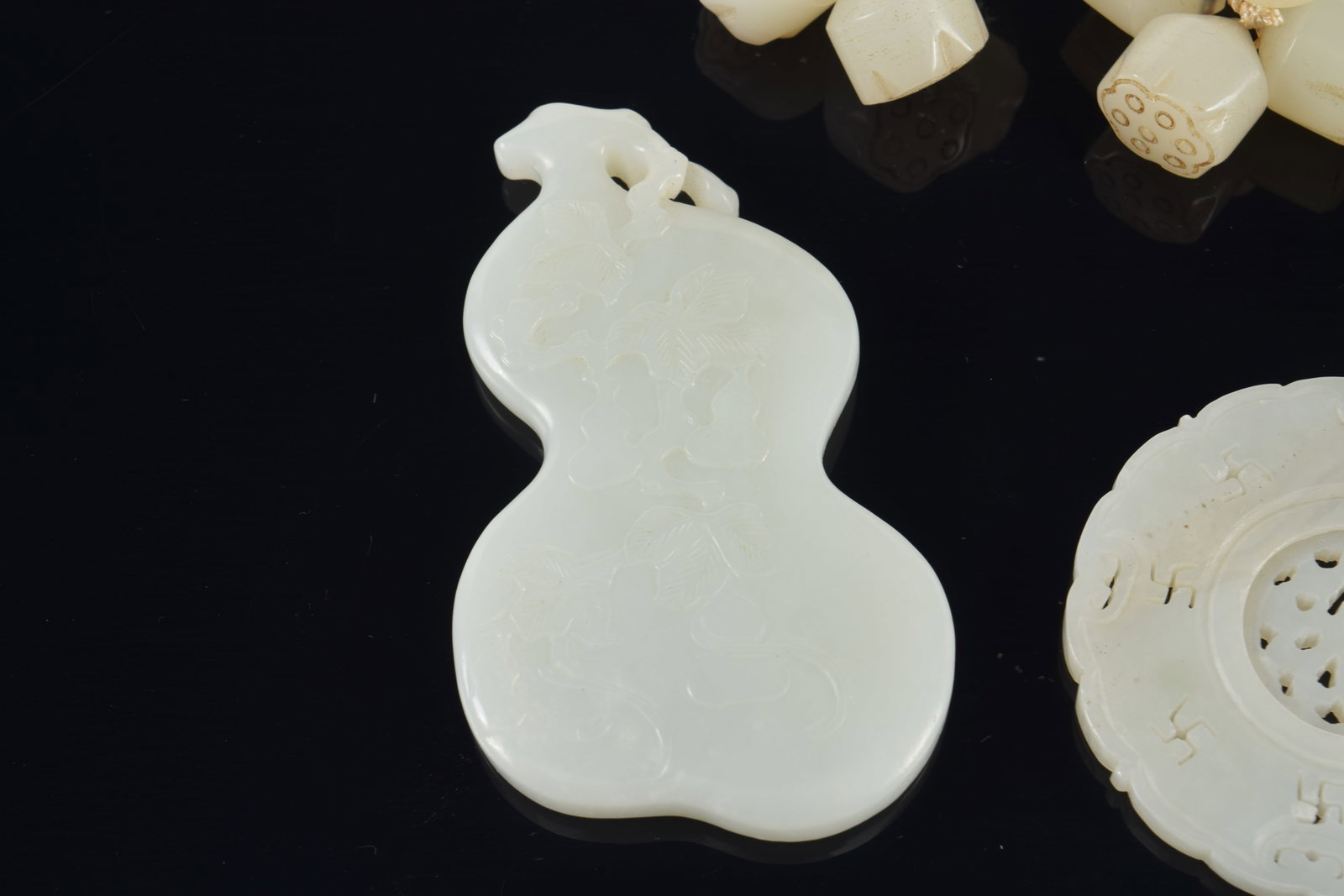 4 jade pendants. China. 19th century. Together with a group of jade lotus beads. Largest 3in. - 5